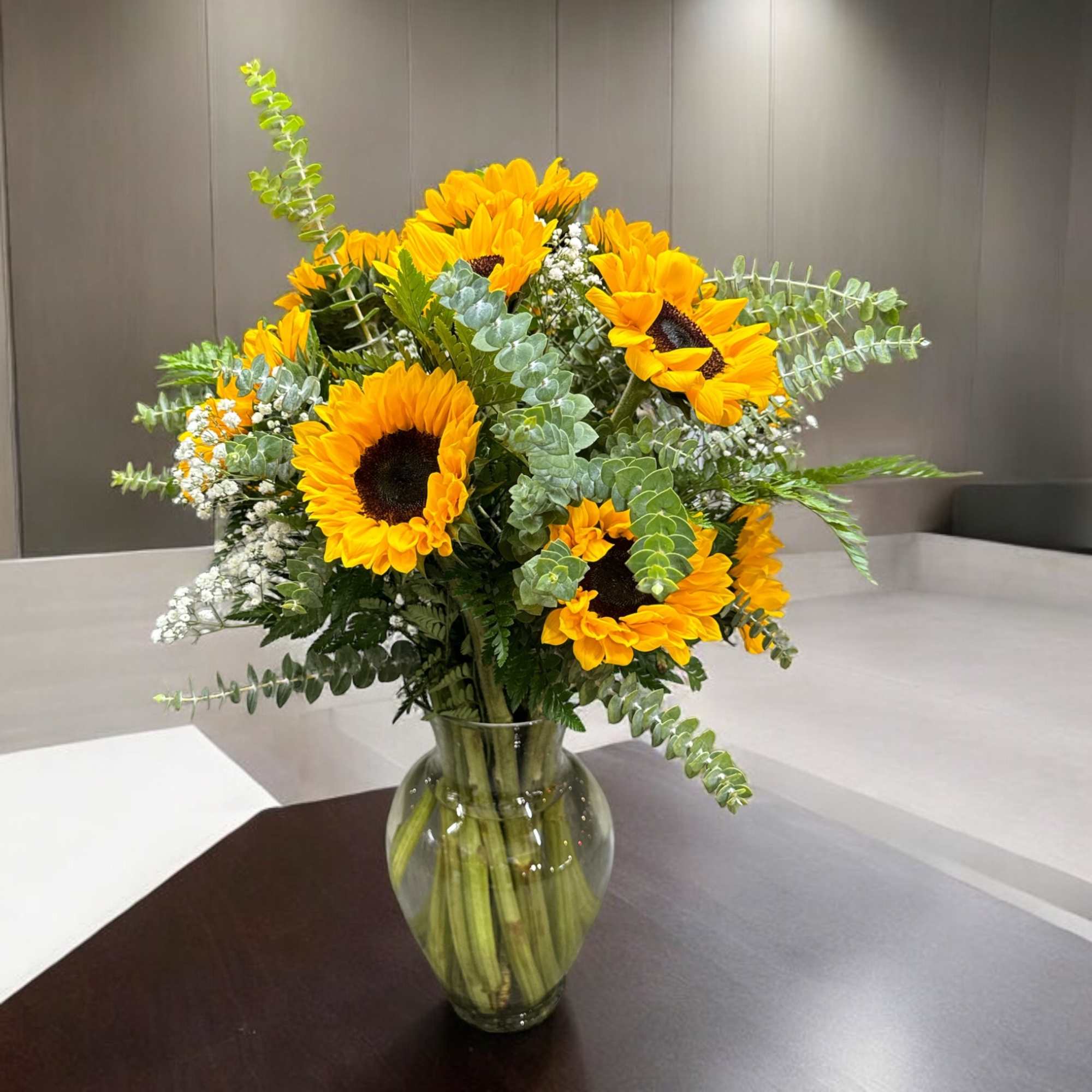 Bouquet of yellow sunflowers in a clear glass vase