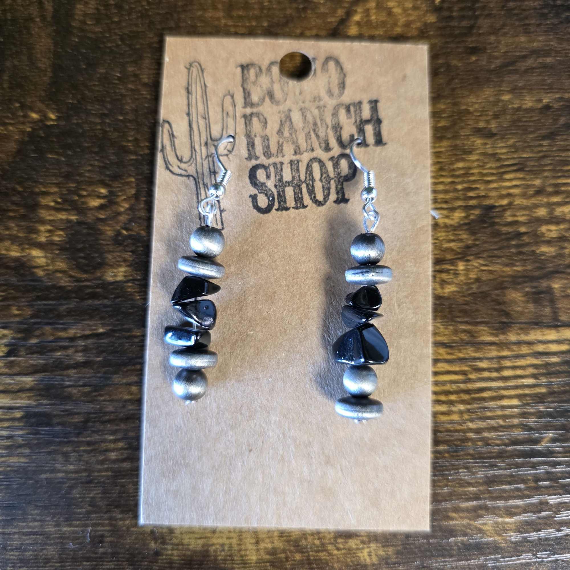 Pair of beaded drop earrings on a cardboard display card