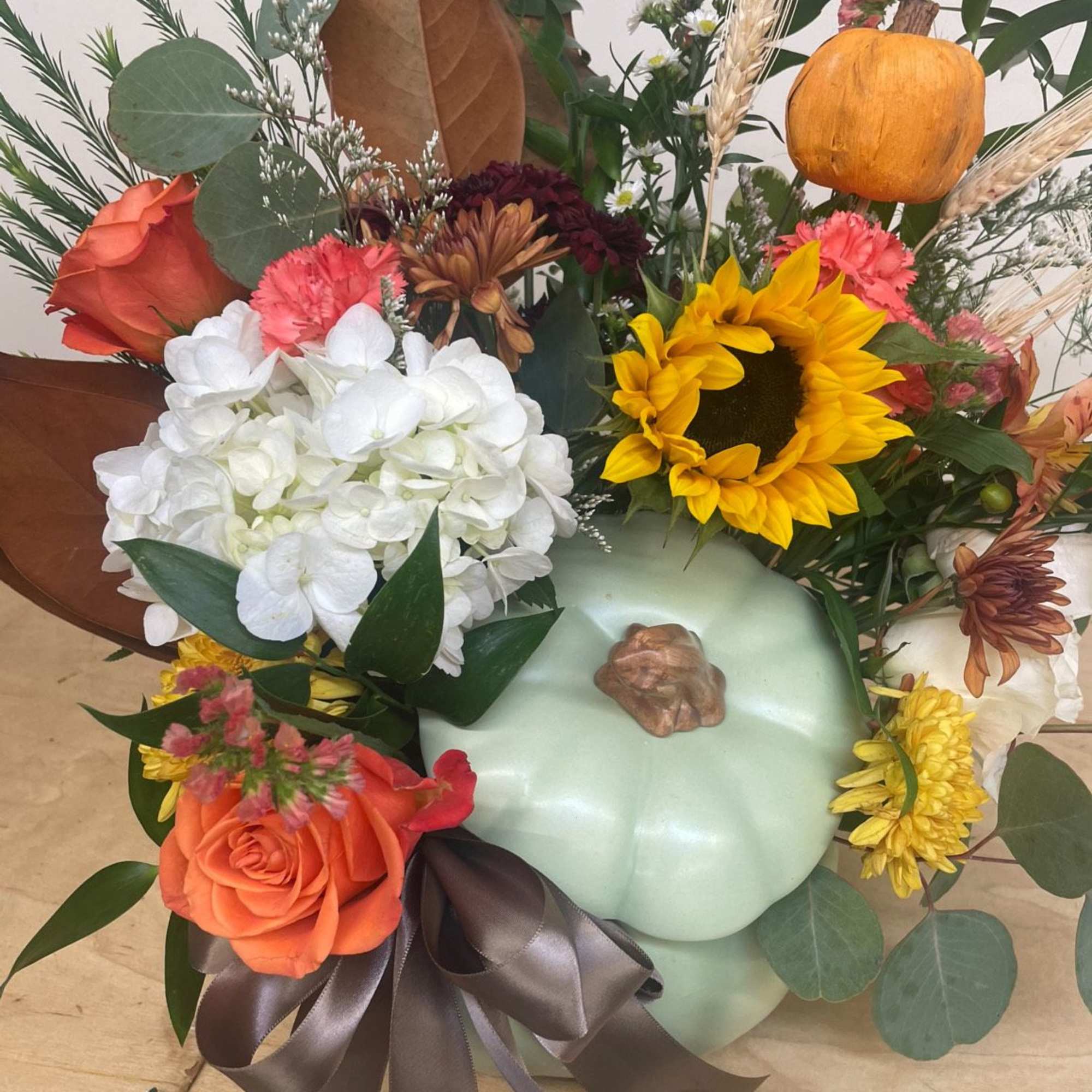Autumn bouquet with sunflowers, roses, hydrangea, and a pumpkin accent