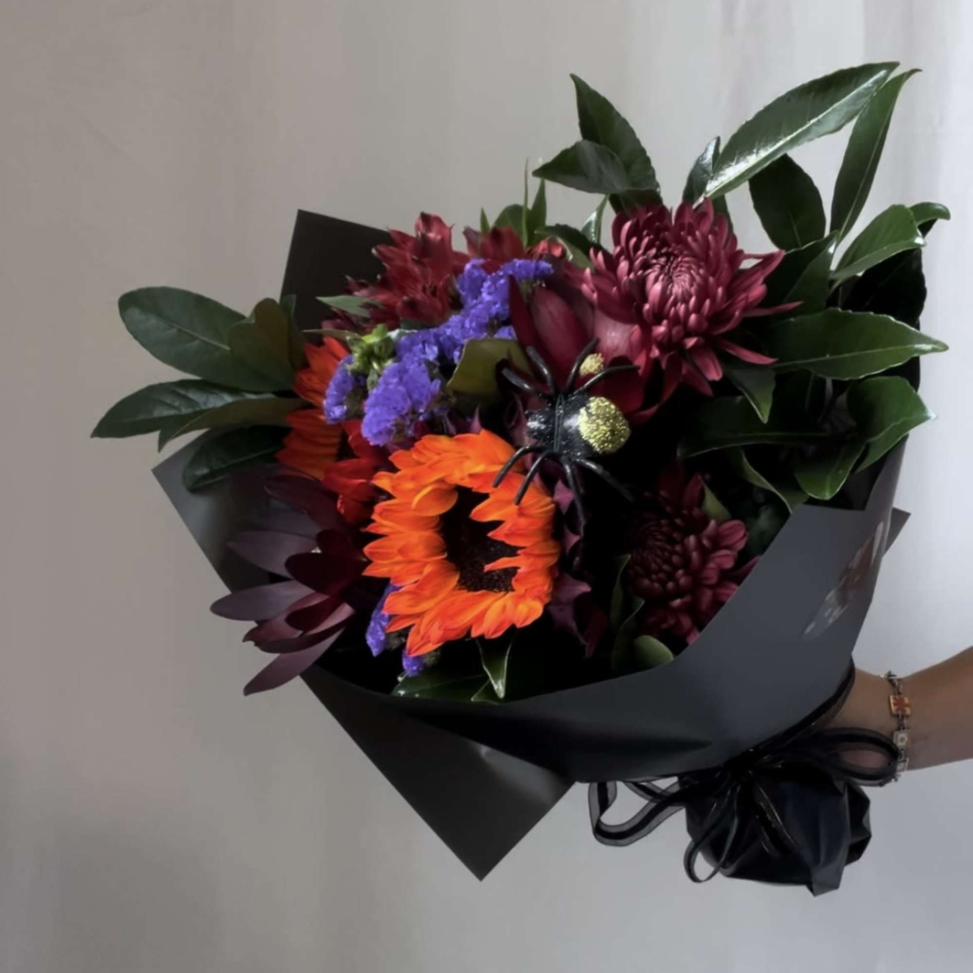 Bouquet of orange and burgundy flowers wrapped in black paper, photo 3 of 9