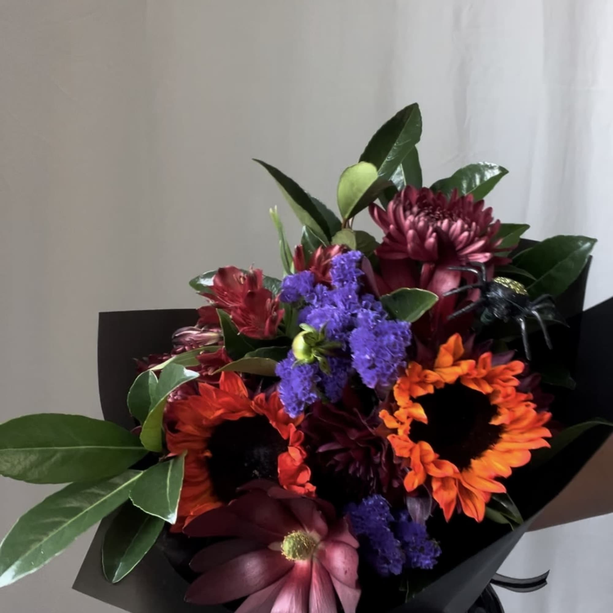 Bouquet of orange and burgundy flowers wrapped in black paper, photo 8 of 9
