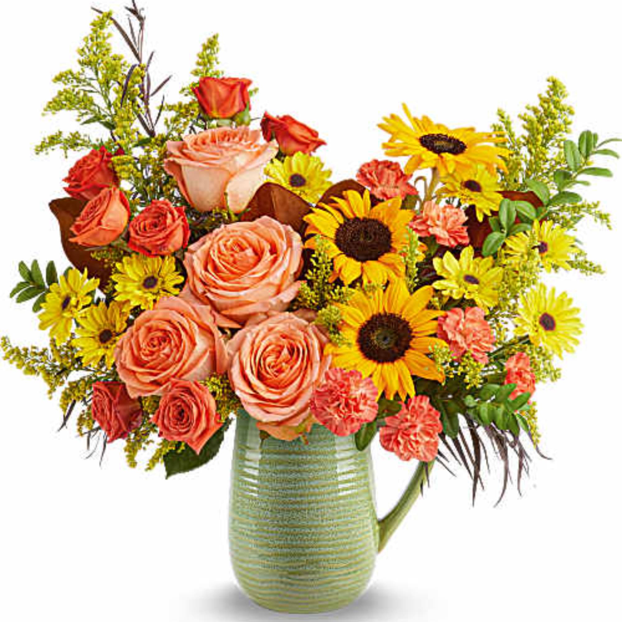Mixed bouquet of roses and sunflowers in a green glass pitcher vase