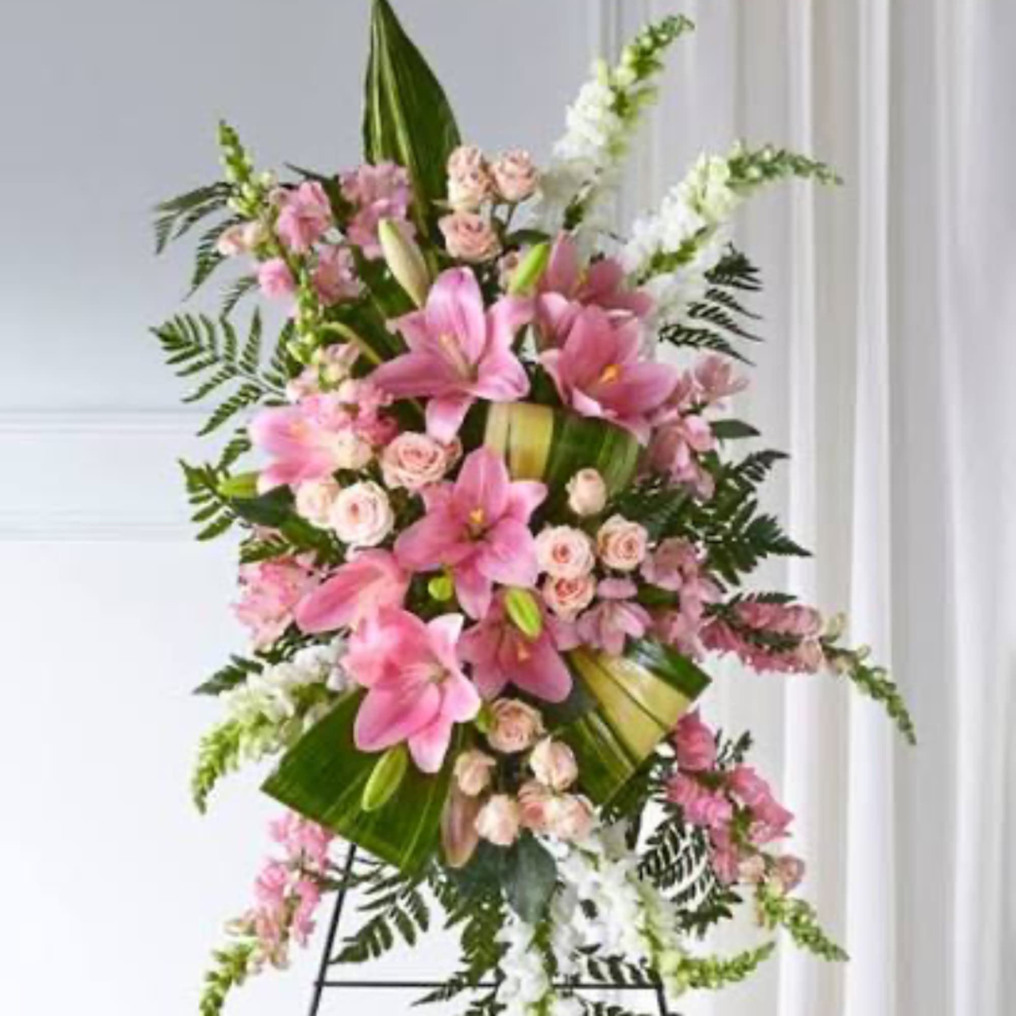 Pink and white floral standing spray on a black easel