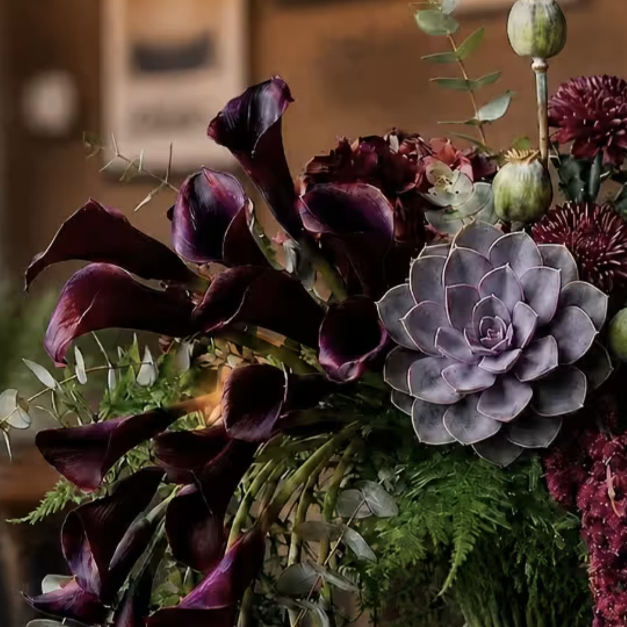 Dark purple calla lilies and a gray succulent in a mixed bouquet