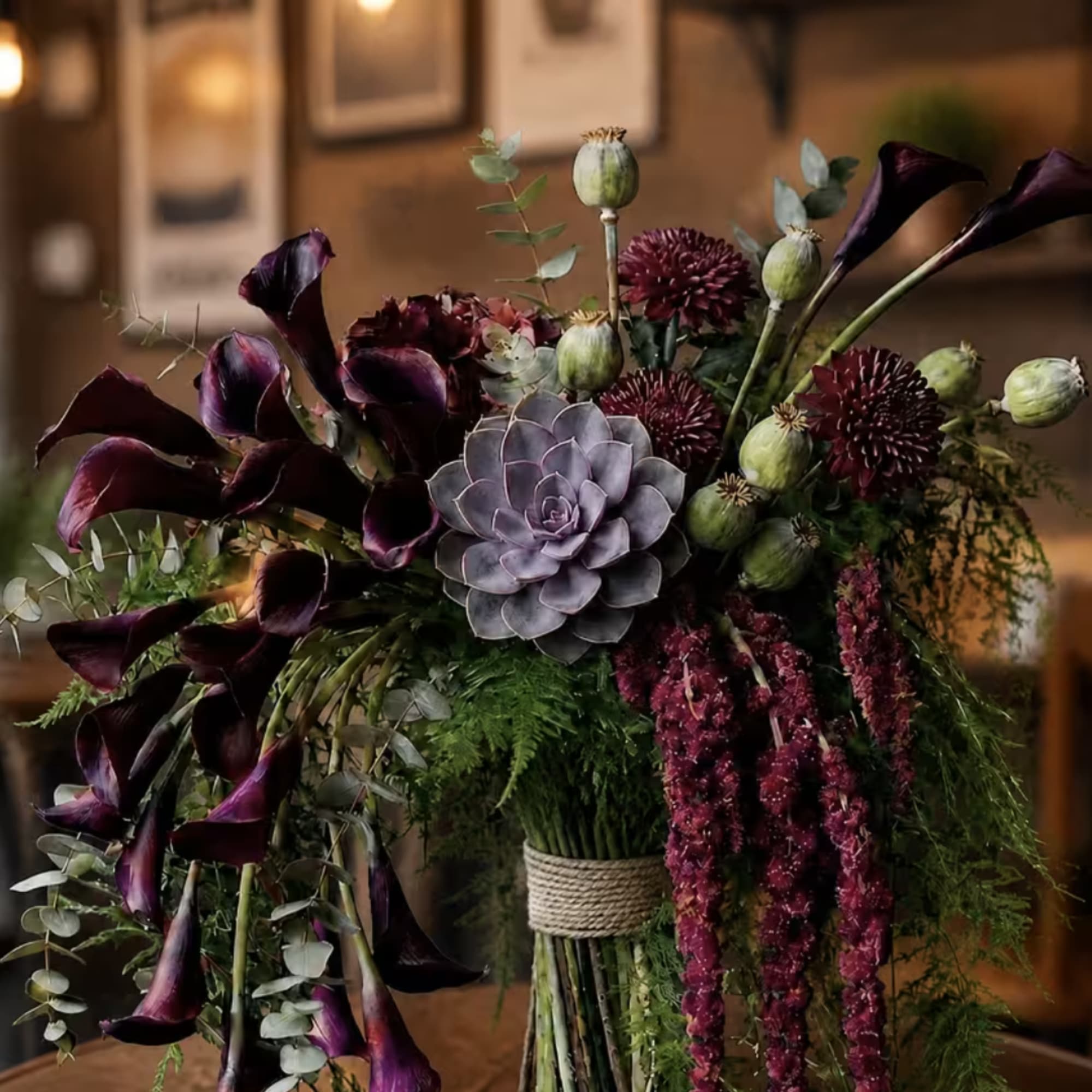 Dark purple calla lilies and a lavender succulent in a bouquet