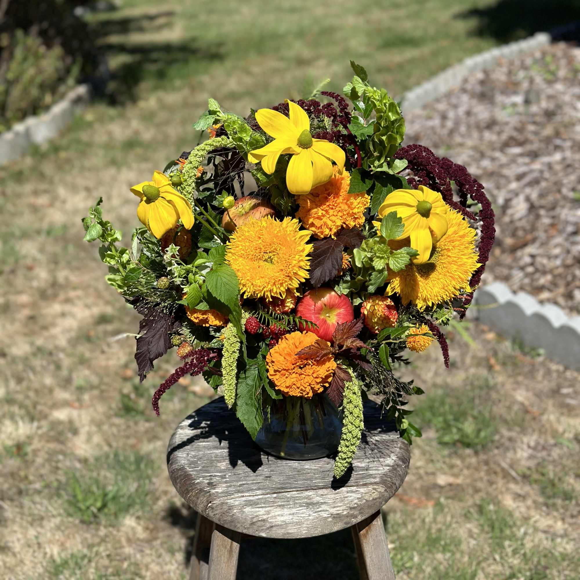 Bright mixed bouquet in a dark vase with yellow and orange blooms