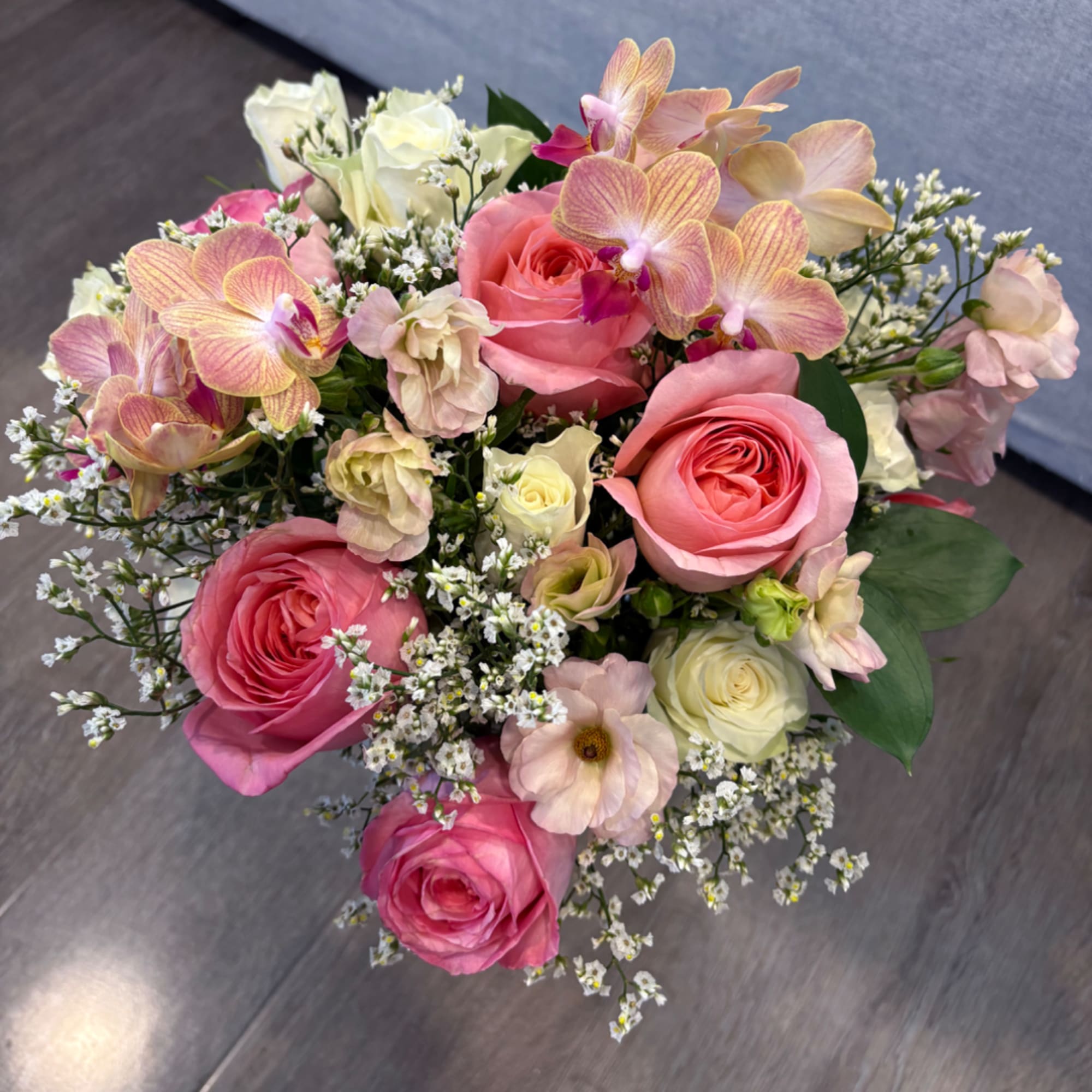 Bouquet of pink and white roses with pale orchids and small white filler flowers