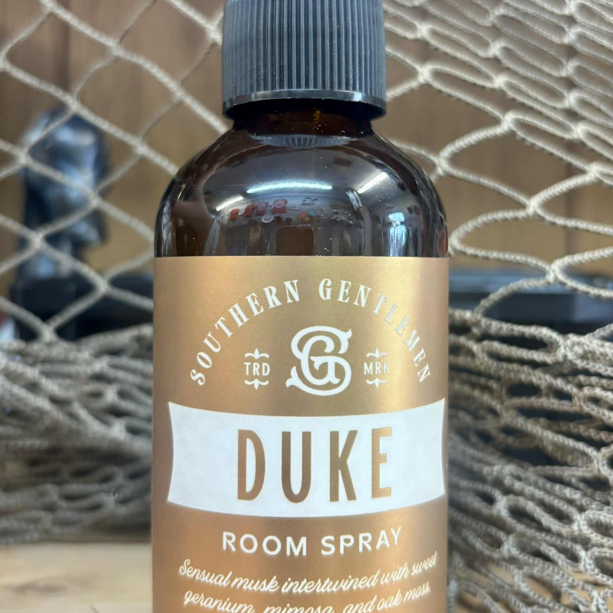 Brown room spray bottle with a pump top and gold label