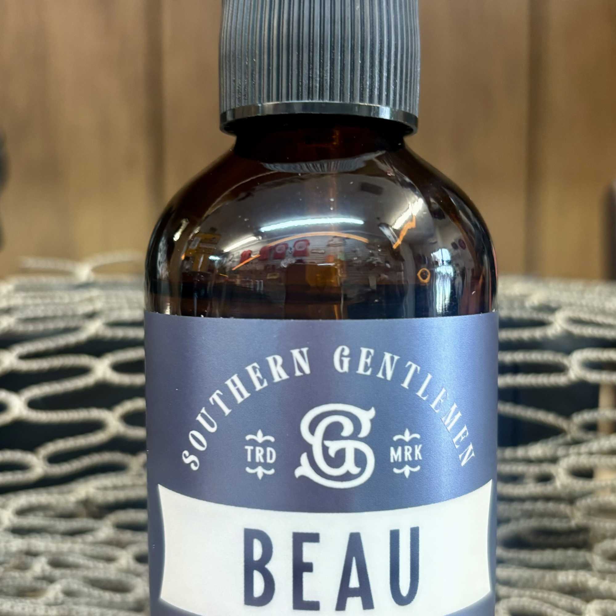 Bottle of Beau room spray with a clear cap and gray label