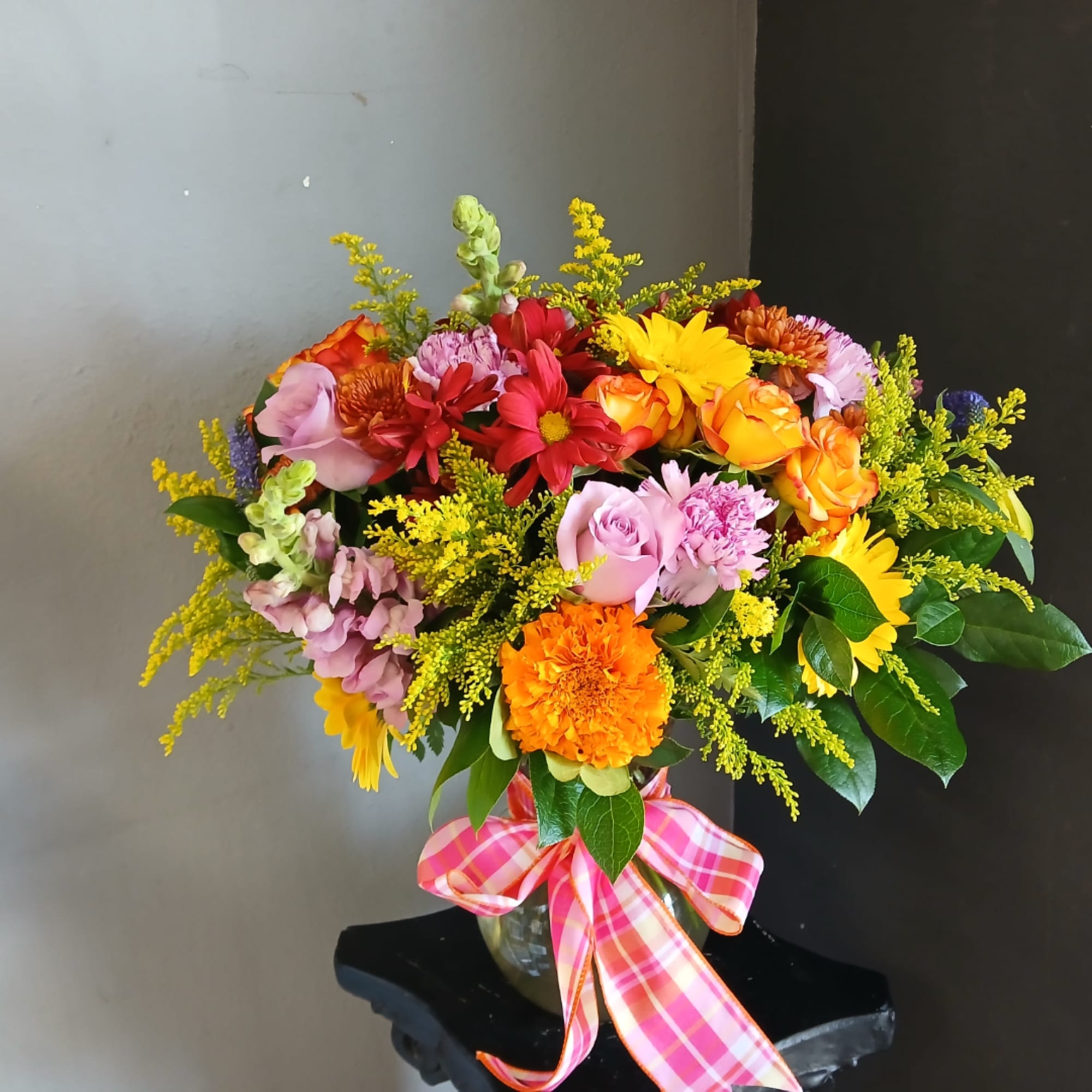Mixed bouquet in a glass vase with a pink plaid ribbon