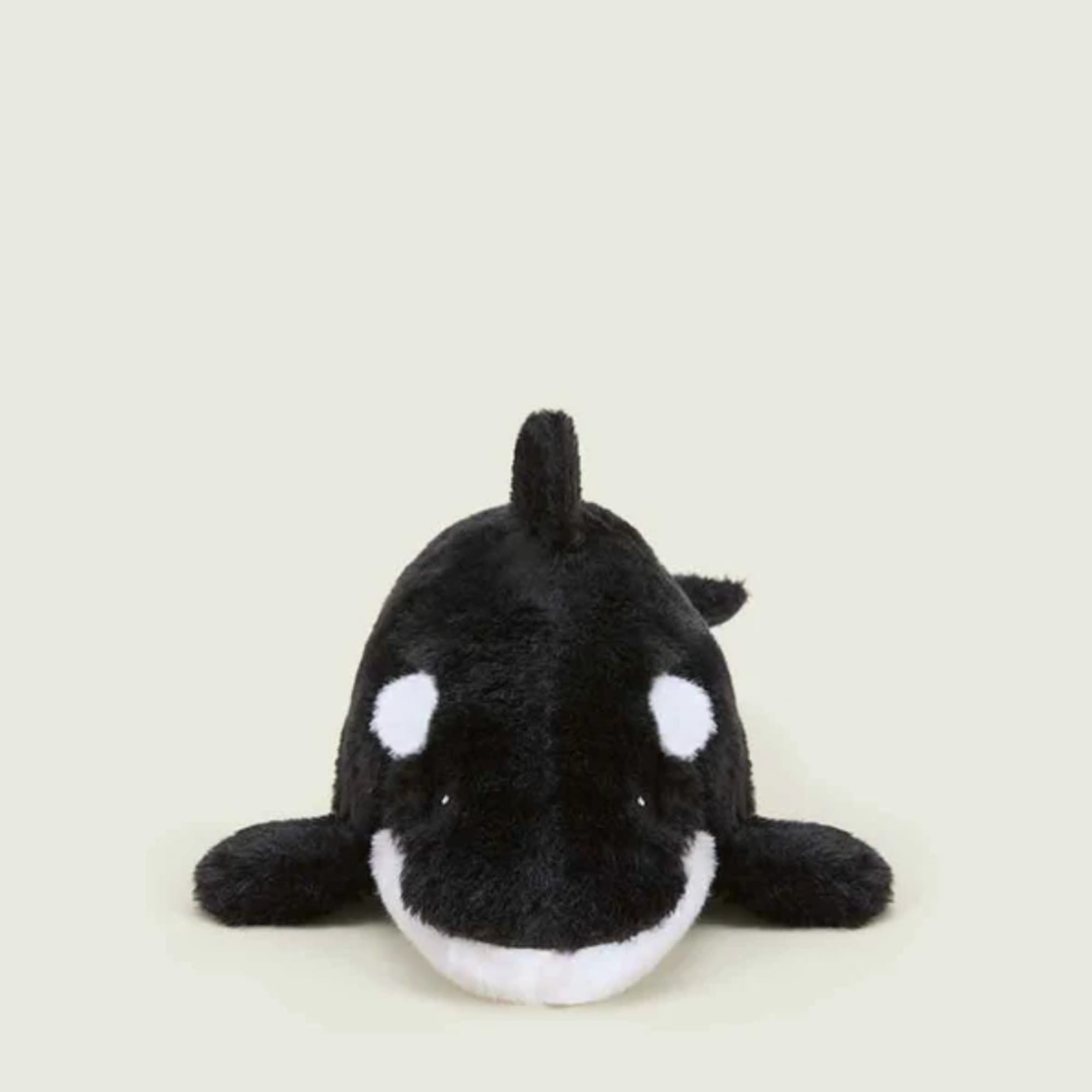 Black and white orca plush toy on a plain background