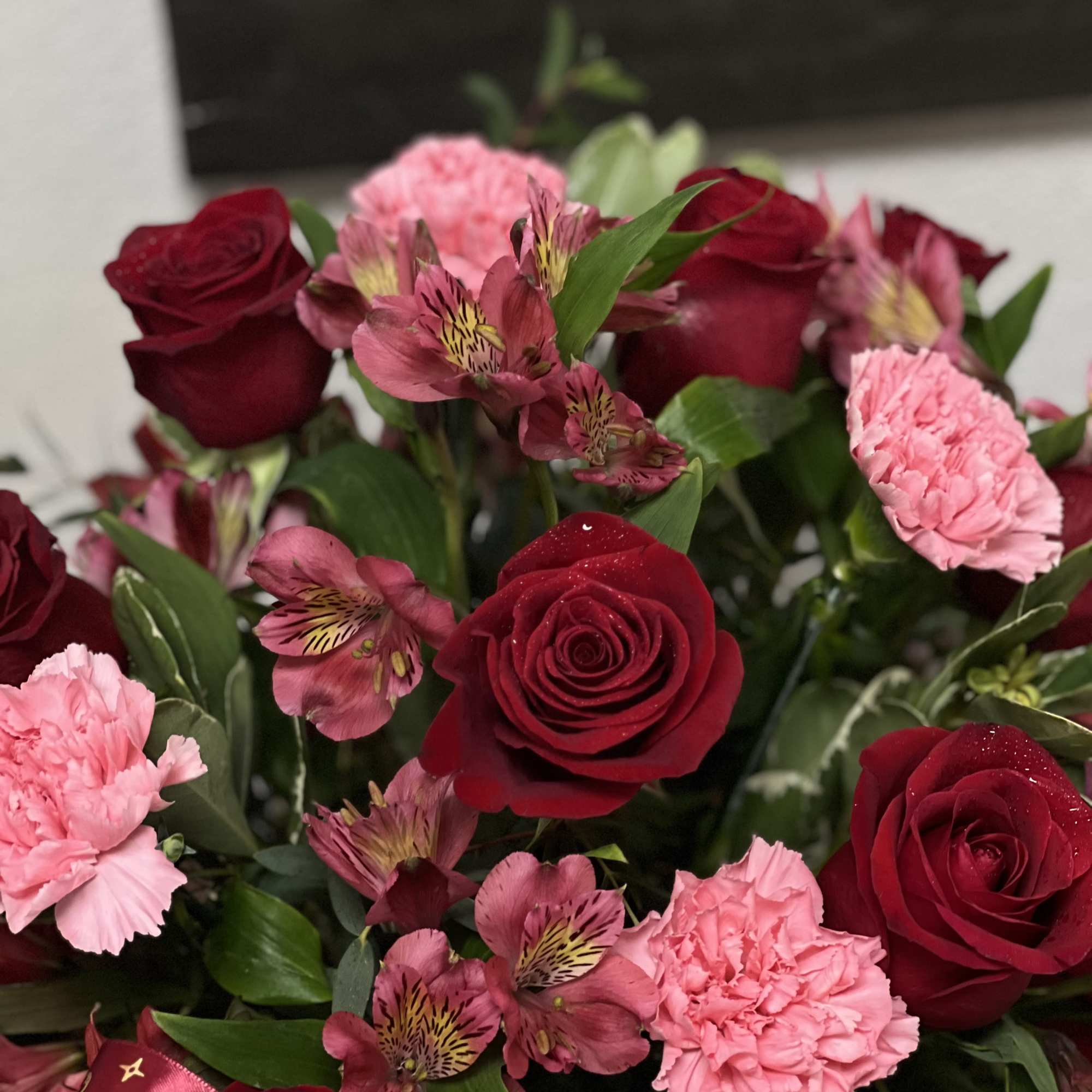 Bouquet of red roses, pink carnations, and pink alstroemeria