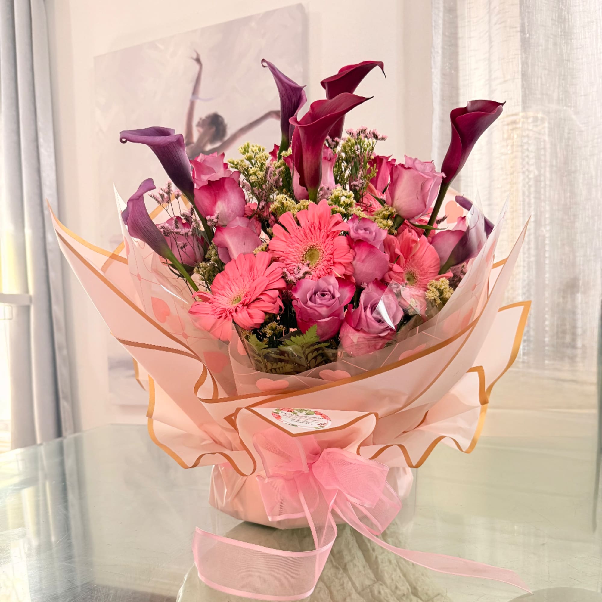 Pink and purple bouquet with roses, gerbera daisies, and calla lilies