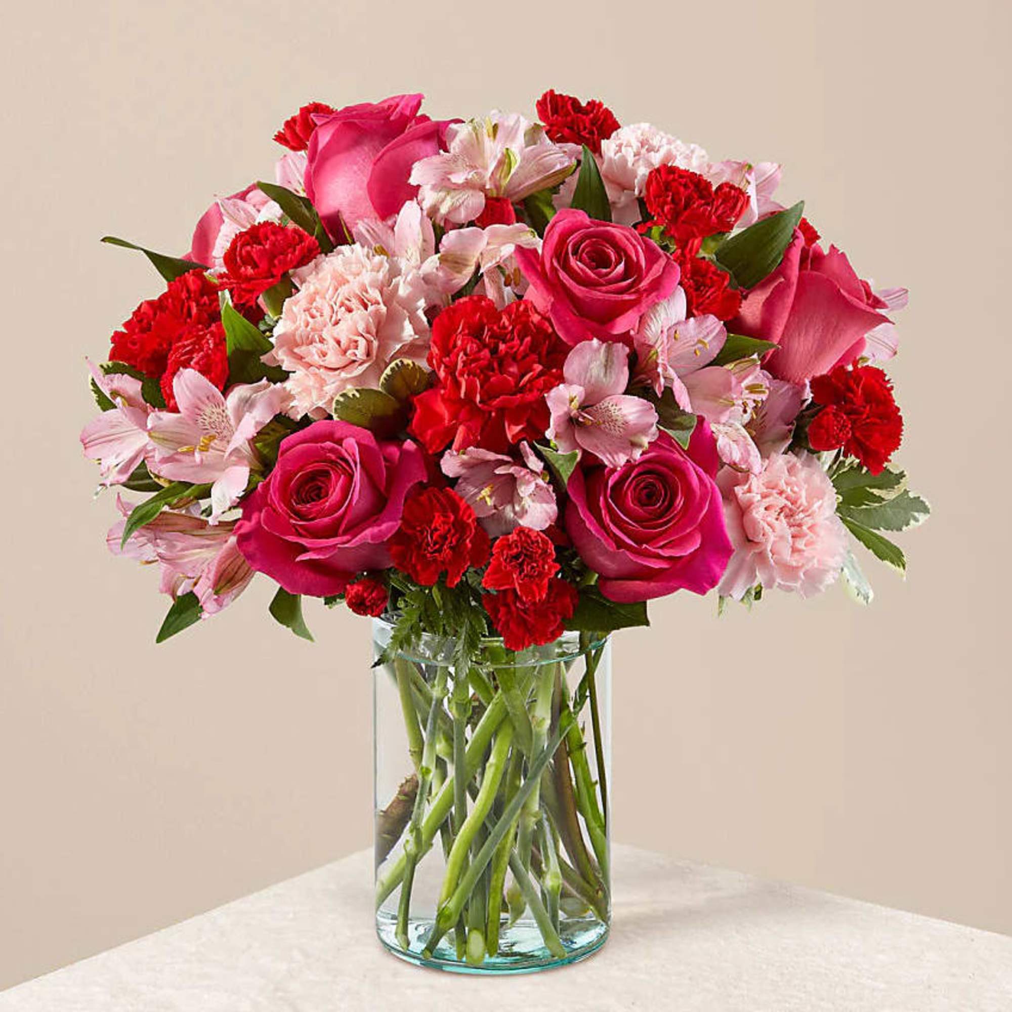 Pink roses and red carnations in a clear glass vase