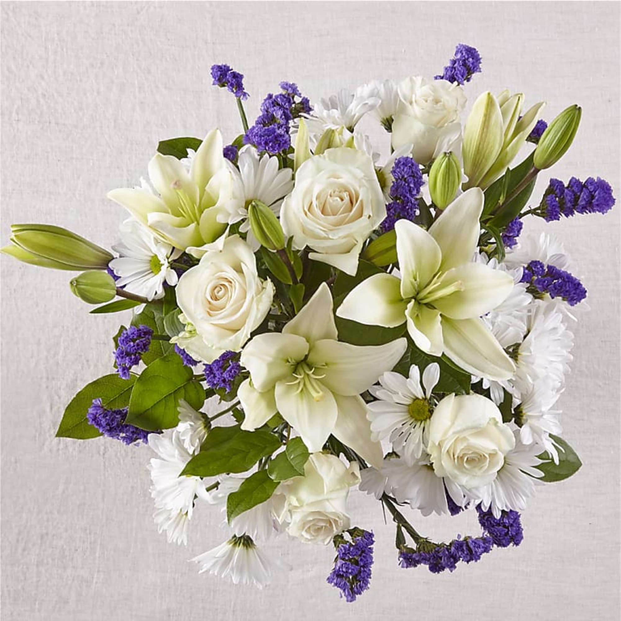 Bouquet of white lilies, roses, and purple filler flowers