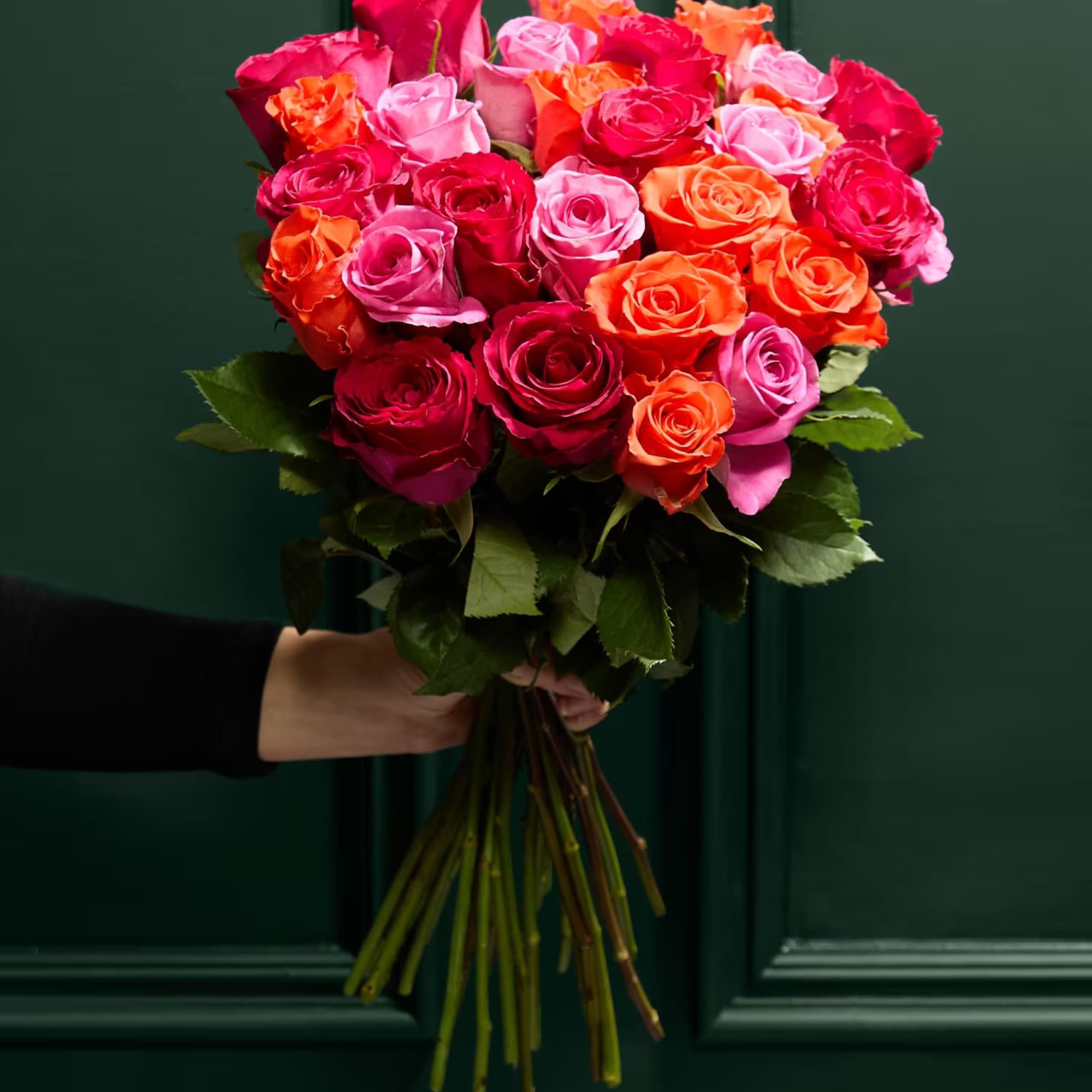 Handheld bouquet of pink, red, and orange roses