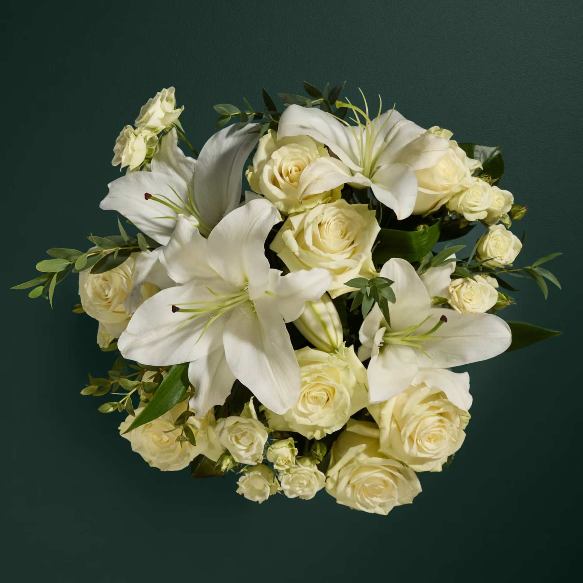 White lilies and cream roses arranged in a bouquet