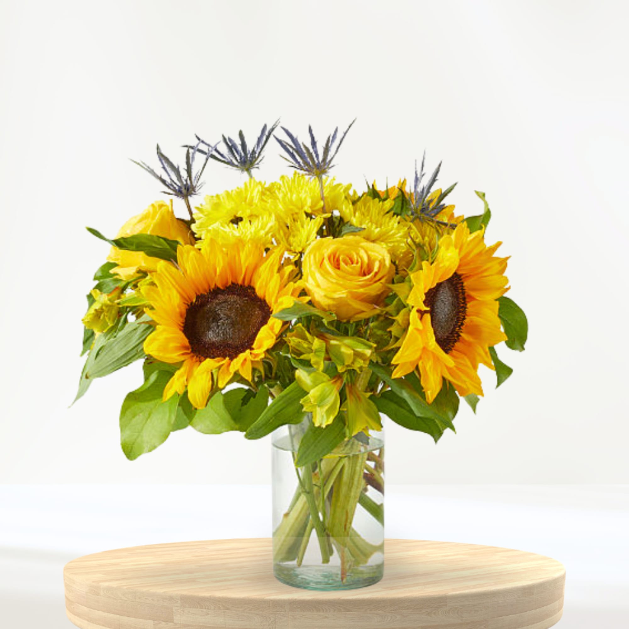 Sunflower and yellow rose bouquet in a clear glass vase
