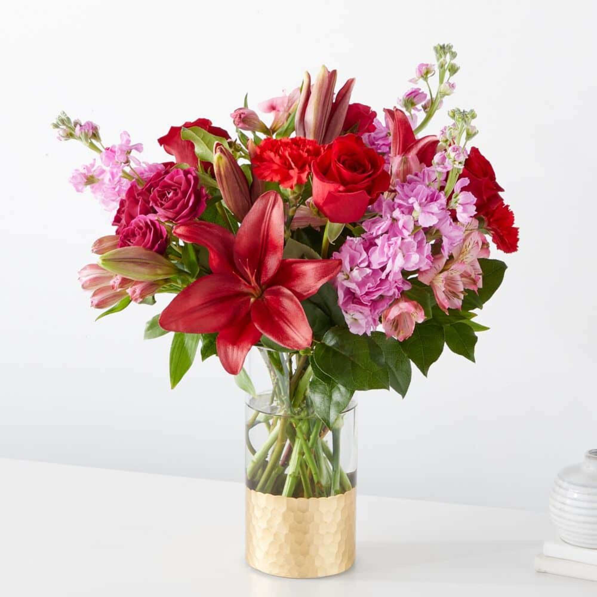 Bouquet of red and pink flowers in a clear glass vase