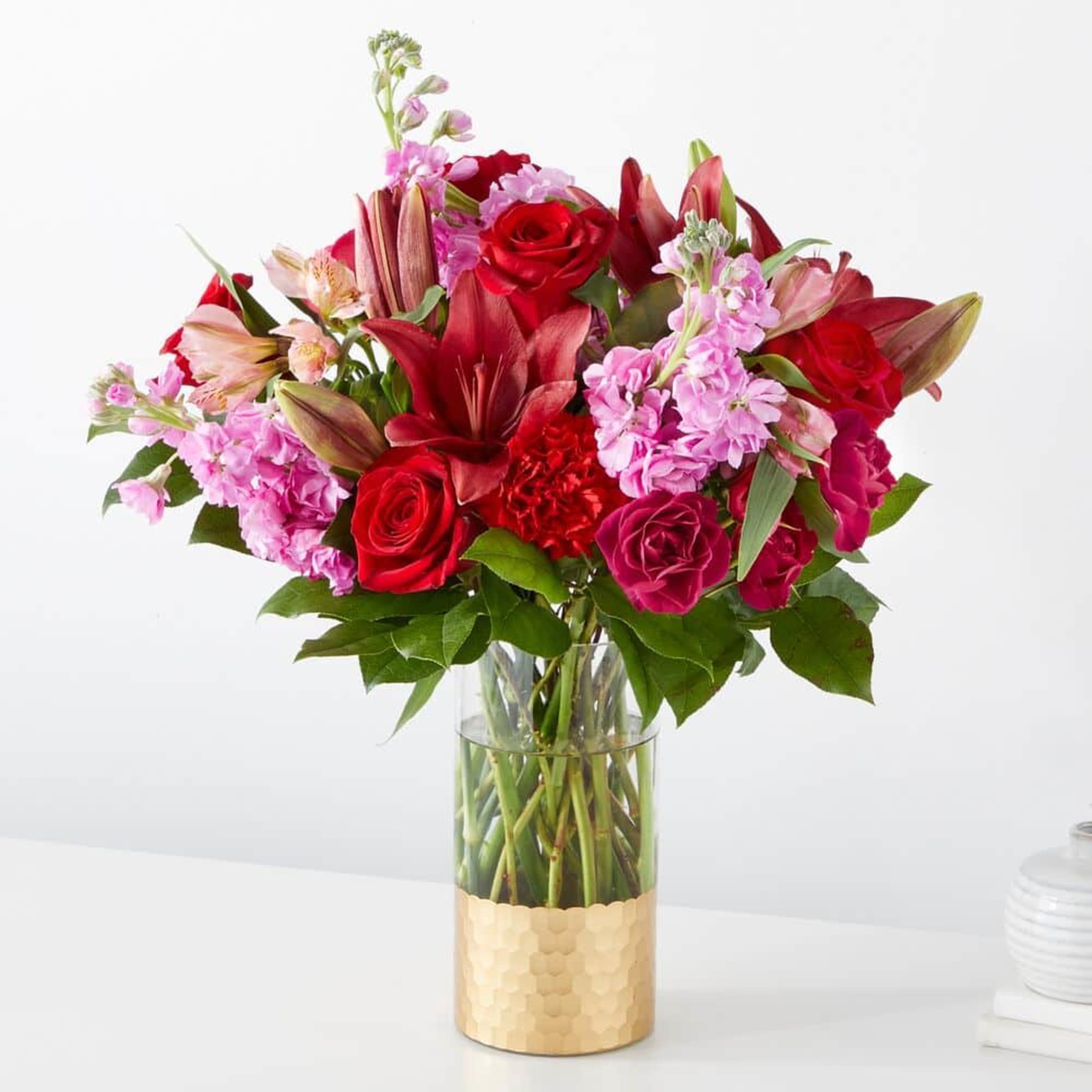 Bouquet of red roses and pink lilies in a glass vase