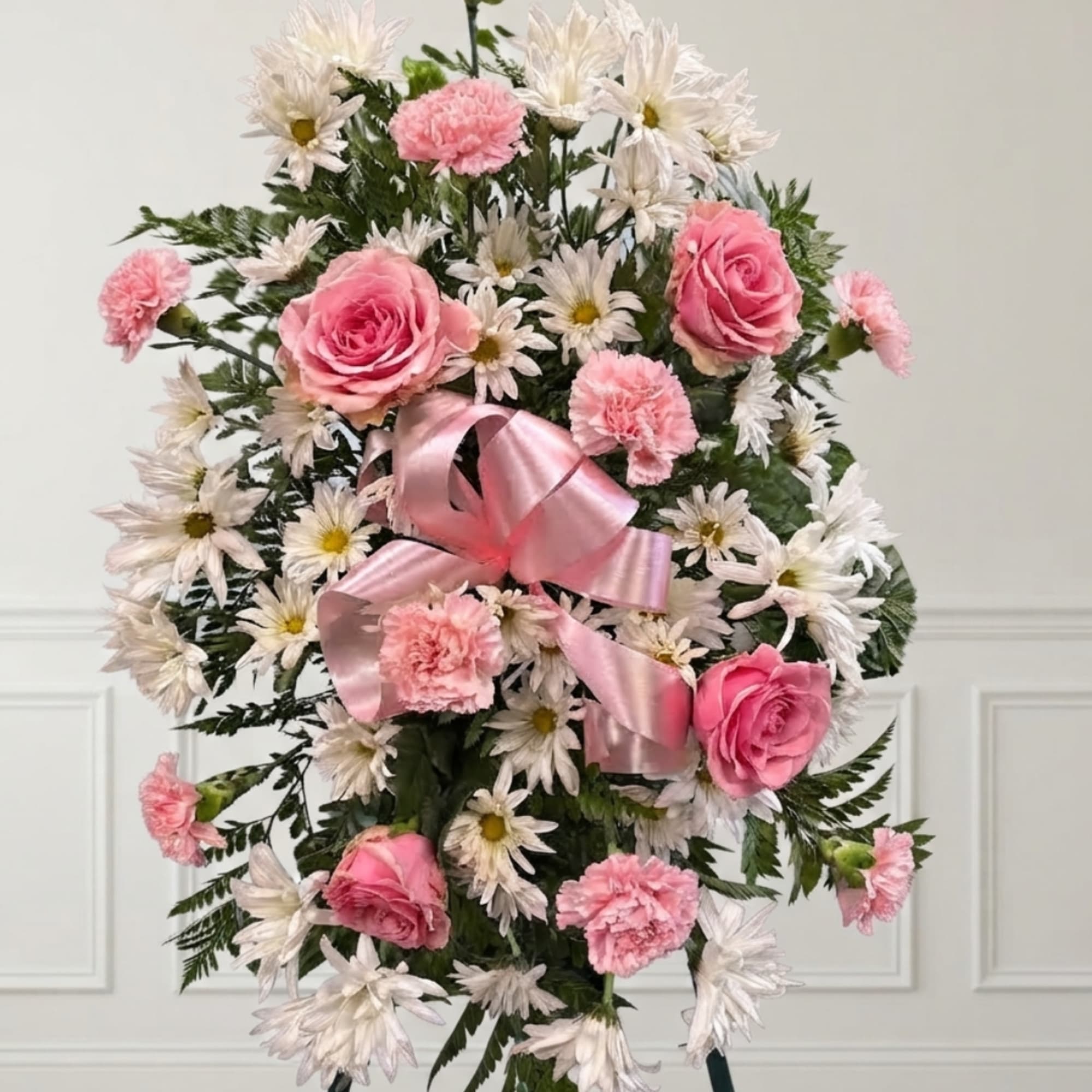 Pink roses and carnations with white daisies in a ribboned arrangement