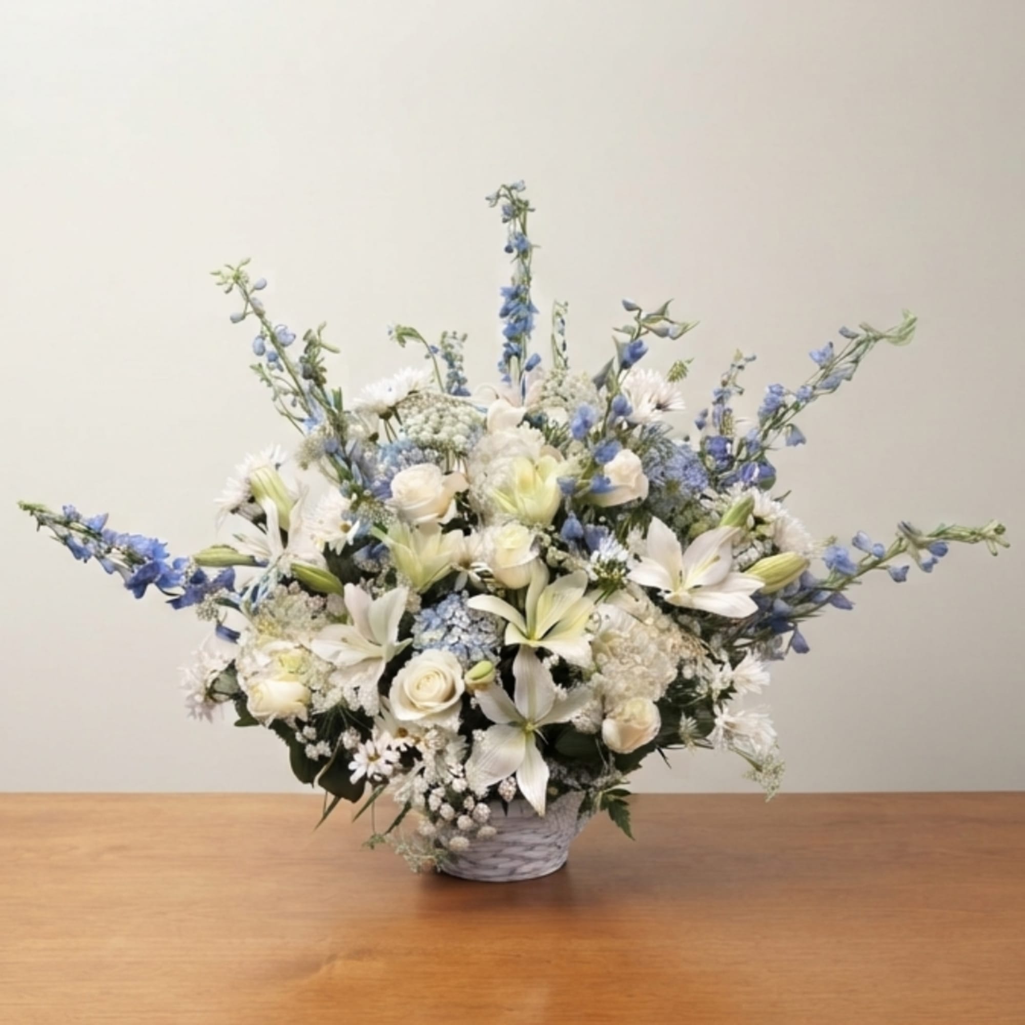 White and blue floral arrangement in a woven basket