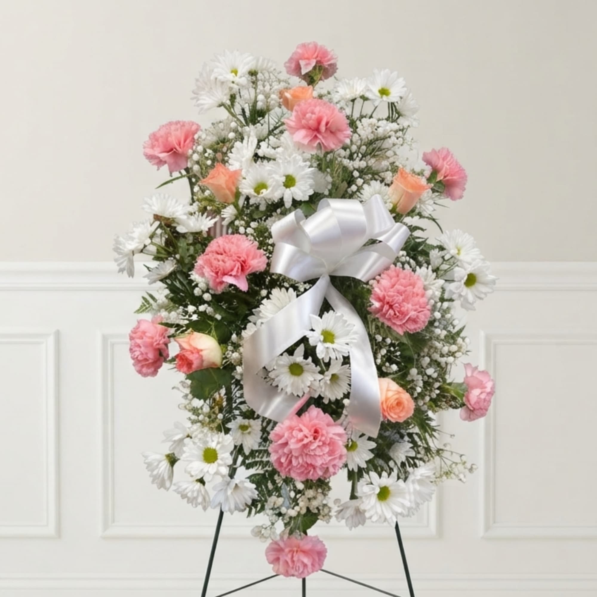Pink and white floral standing spray with a white ribbon bow