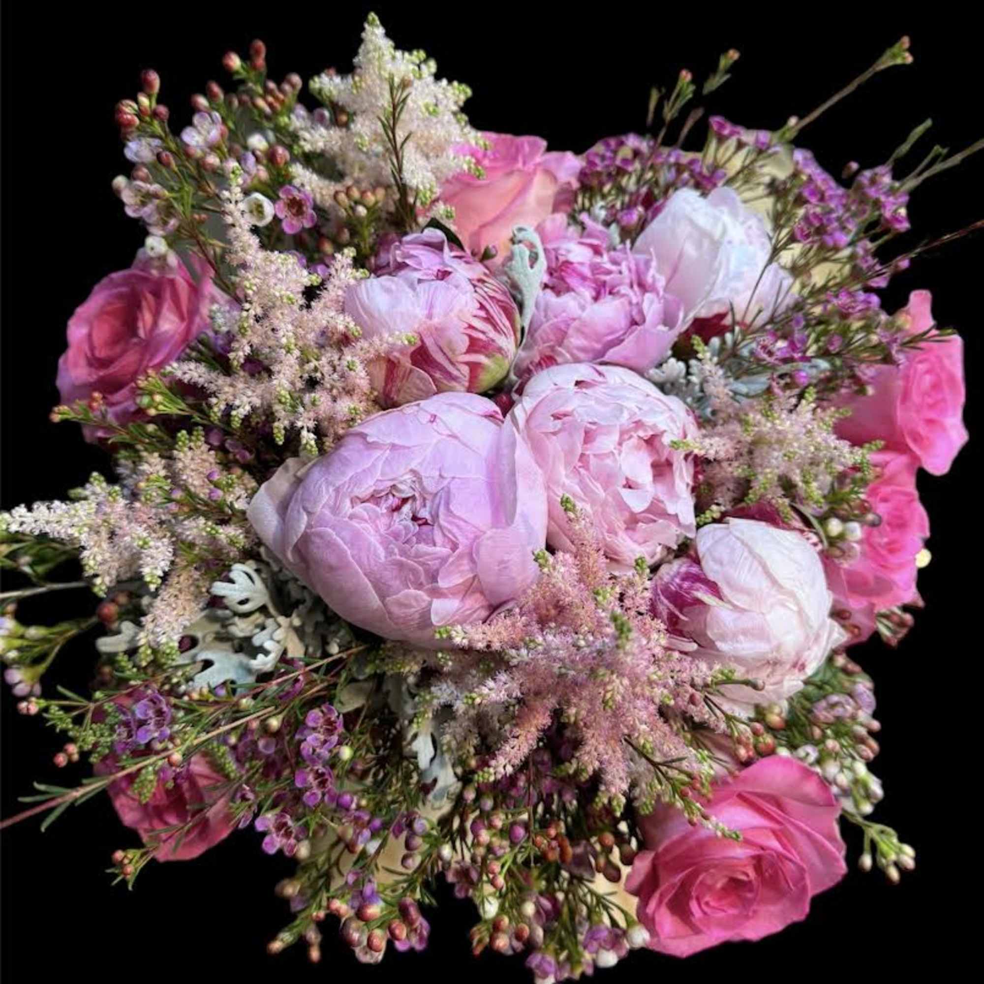 Pink bouquet of peonies and roses with small filler flowers