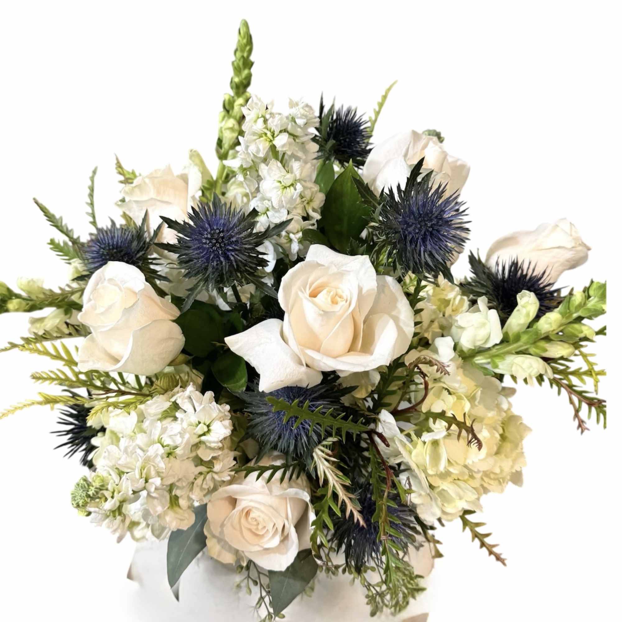 Bouquet of cream roses, white blooms, and blue thistles