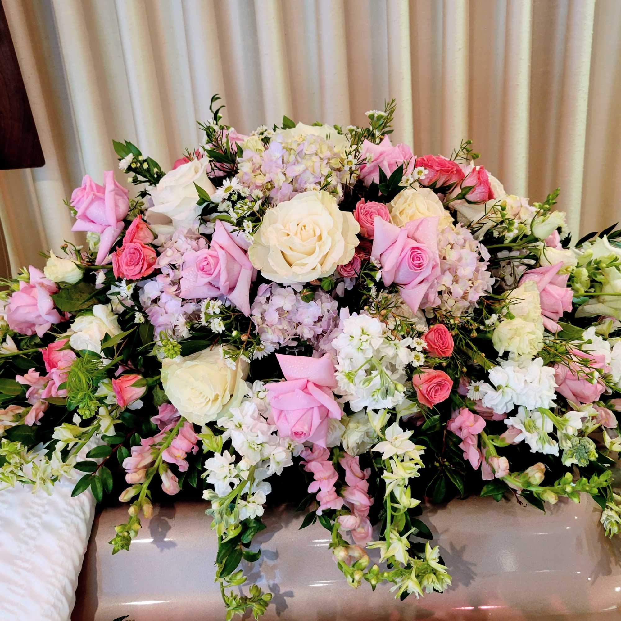 Large pink and white floral arrangement with roses and mixed blooms