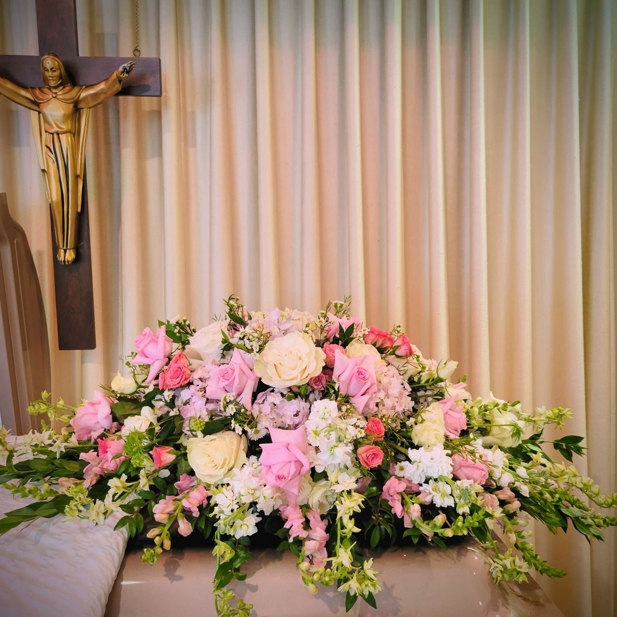 Pink and white floral casket spray with roses and lilies