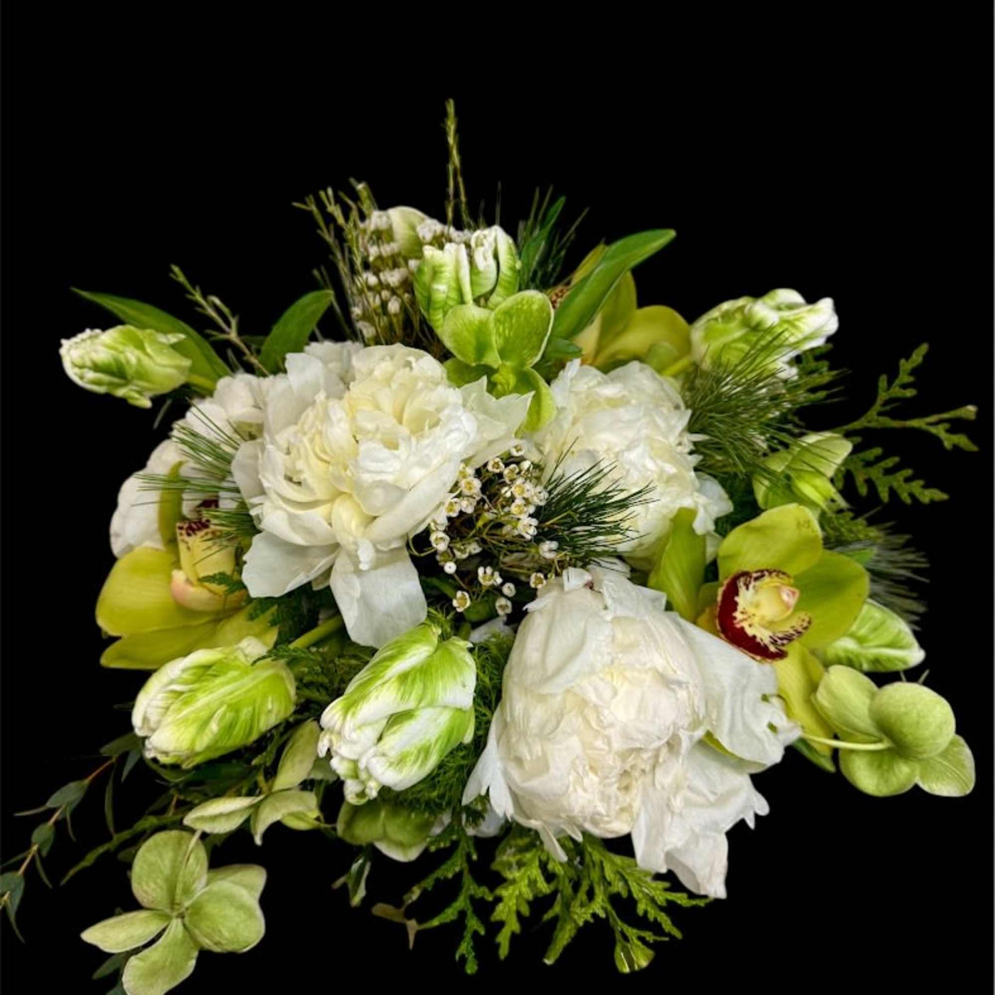 White and green floral bouquet with orchids and peonies on a black background