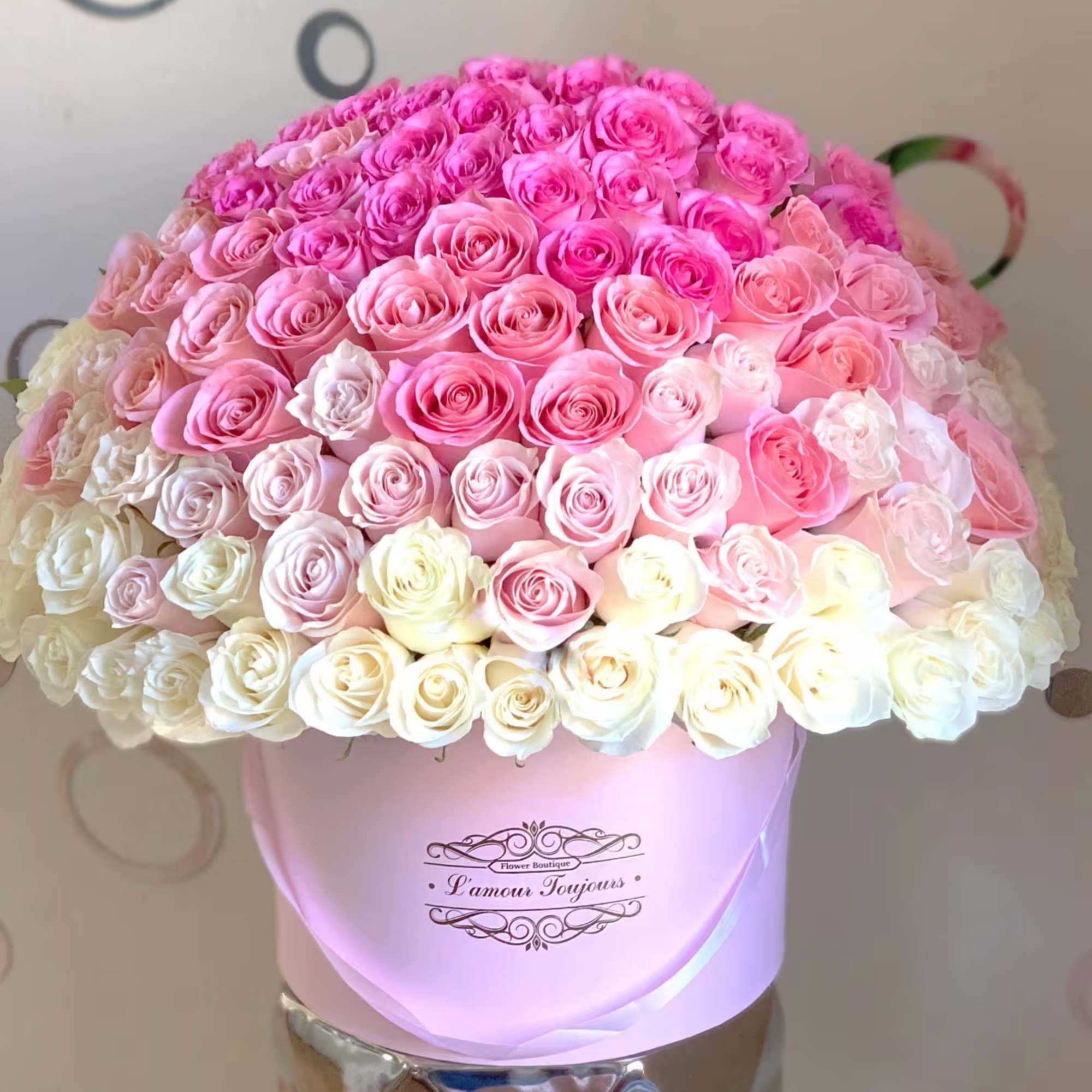 Large bouquet of pink and white roses in a pink hat box