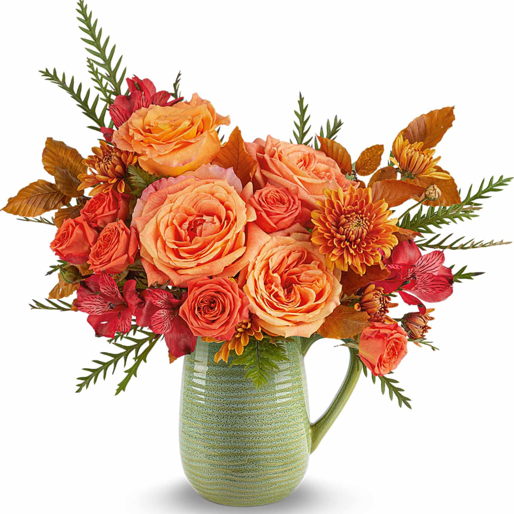 Orange and coral bouquet in a green ceramic pitcher vase