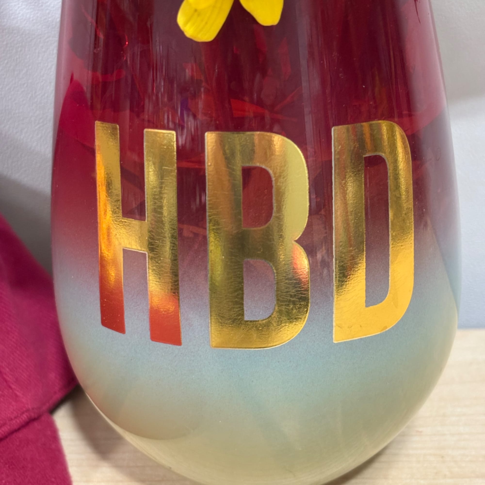 Red vase with gold HBD lettering and a yellow flower inside