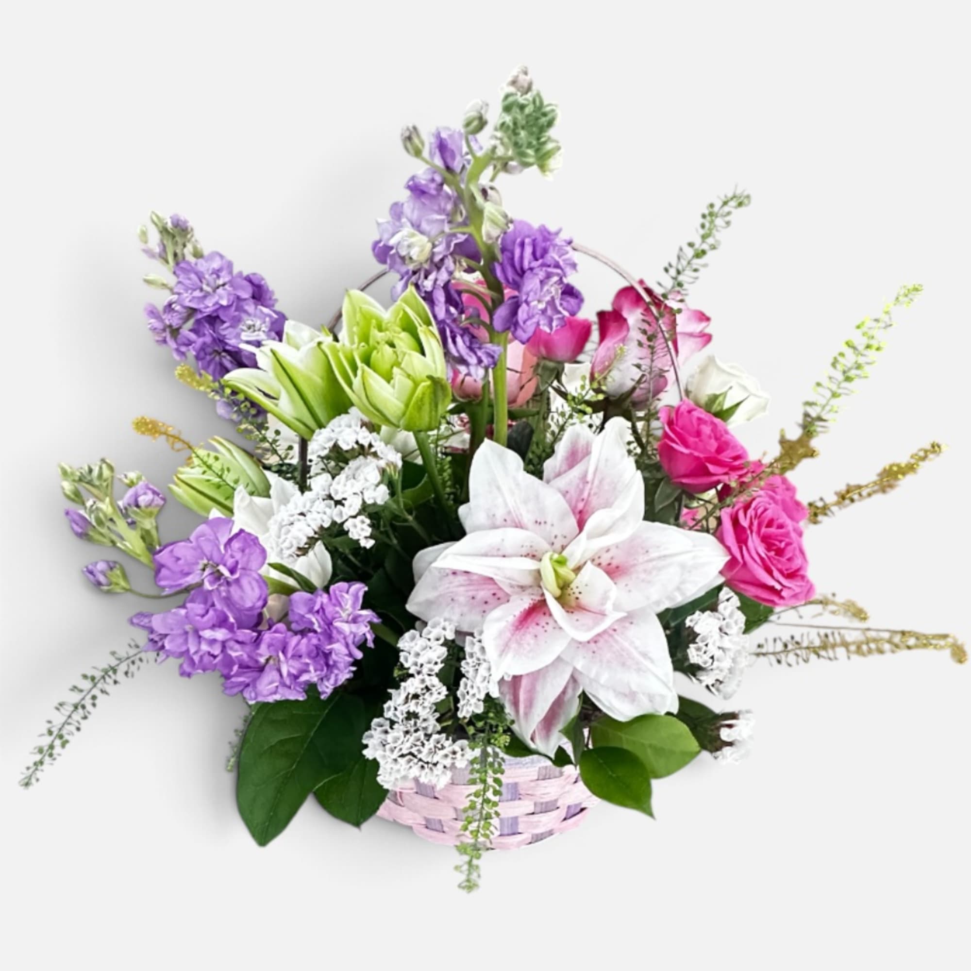 Basket arrangement with pink roses, white lilies, and purple flowers