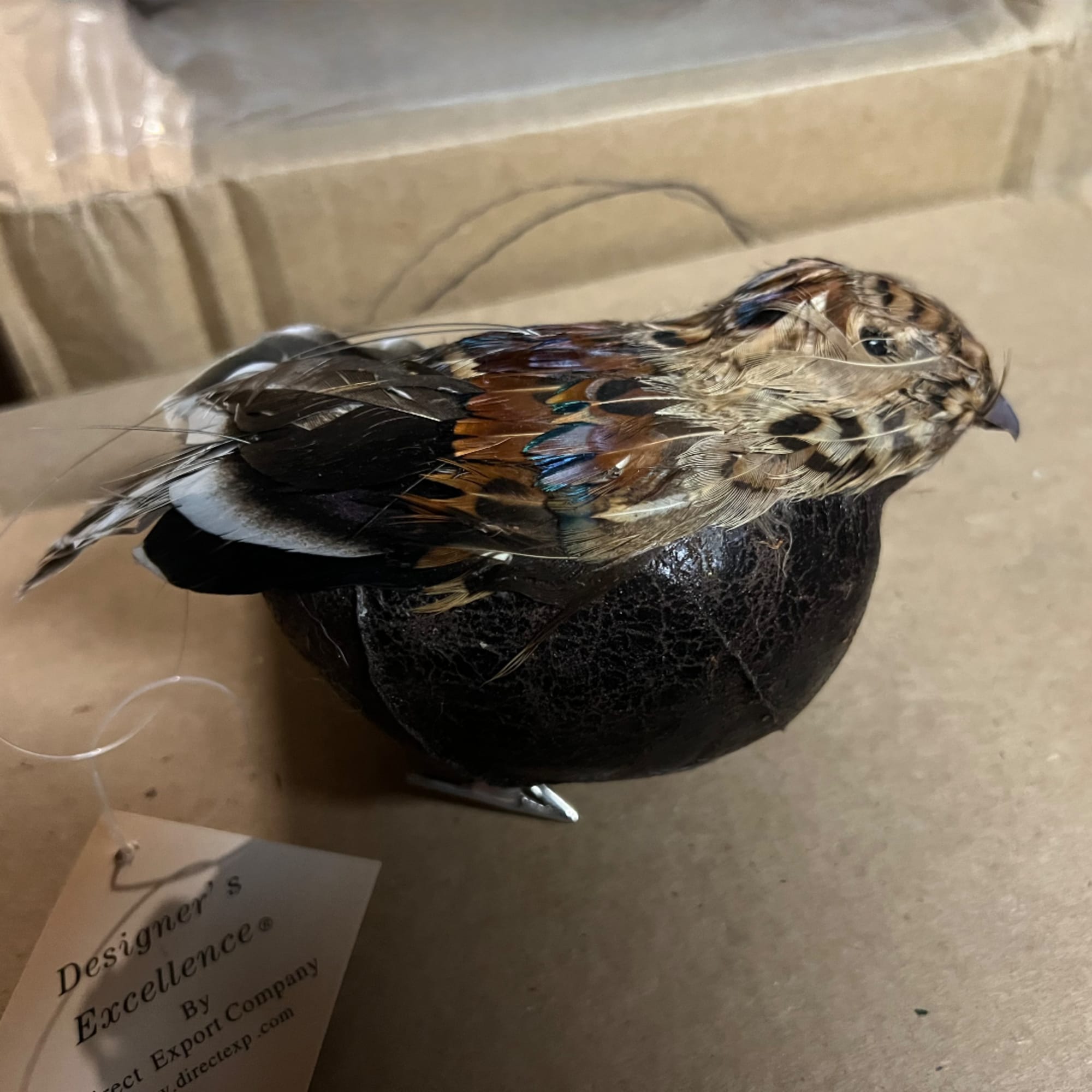 Decorative bird figurine perched on a dark round base