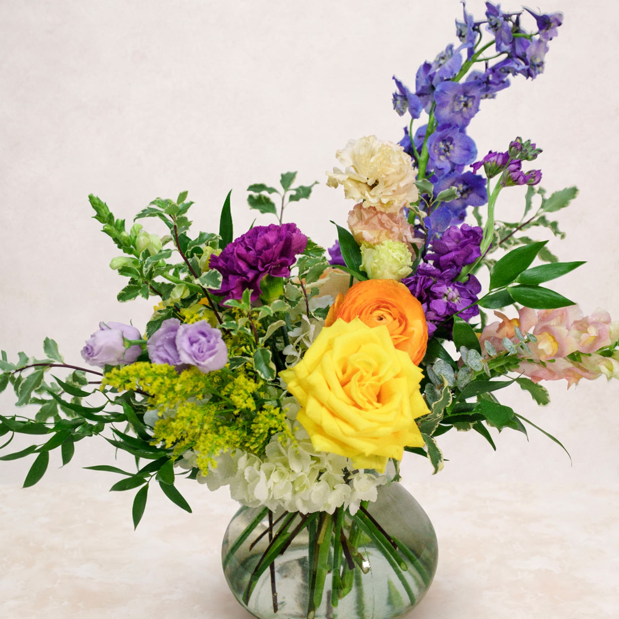 Mixed bouquet with yellow and orange roses in a glass vase