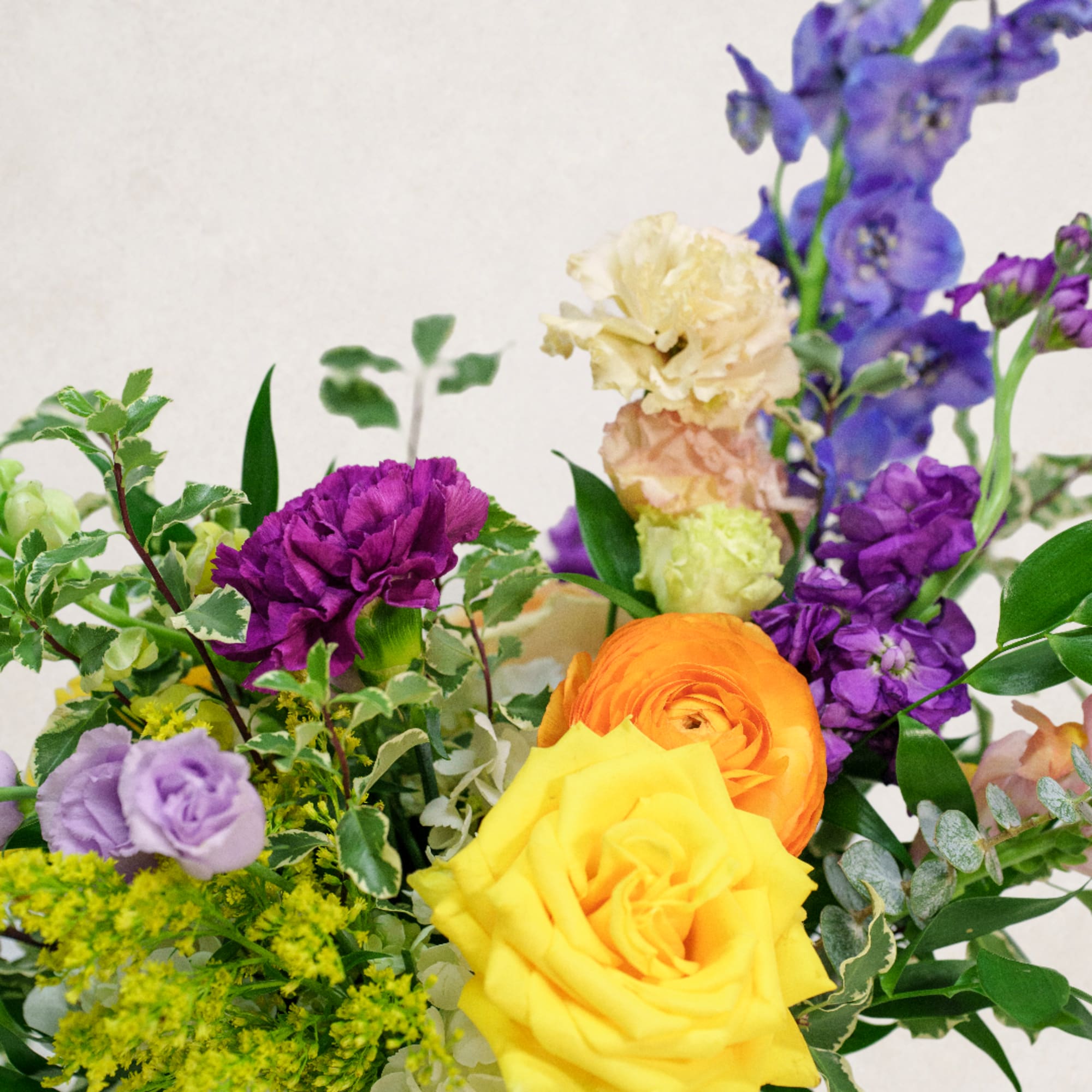 Colorful bouquet with yellow and orange roses and purple flowers