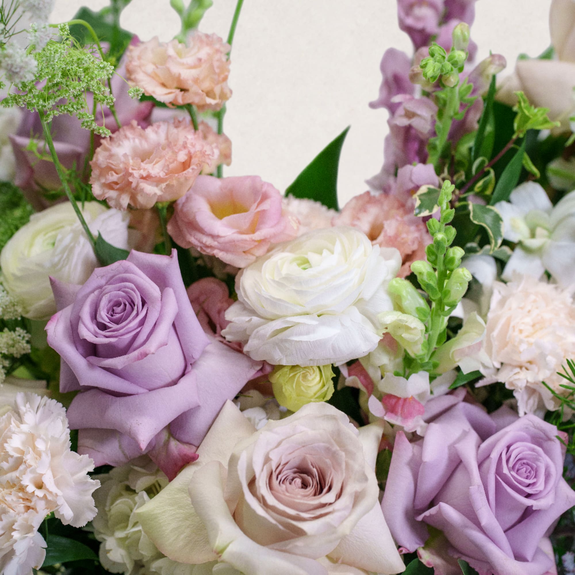 Bouquet of lavender, blush, and white roses with pastel filler flowers