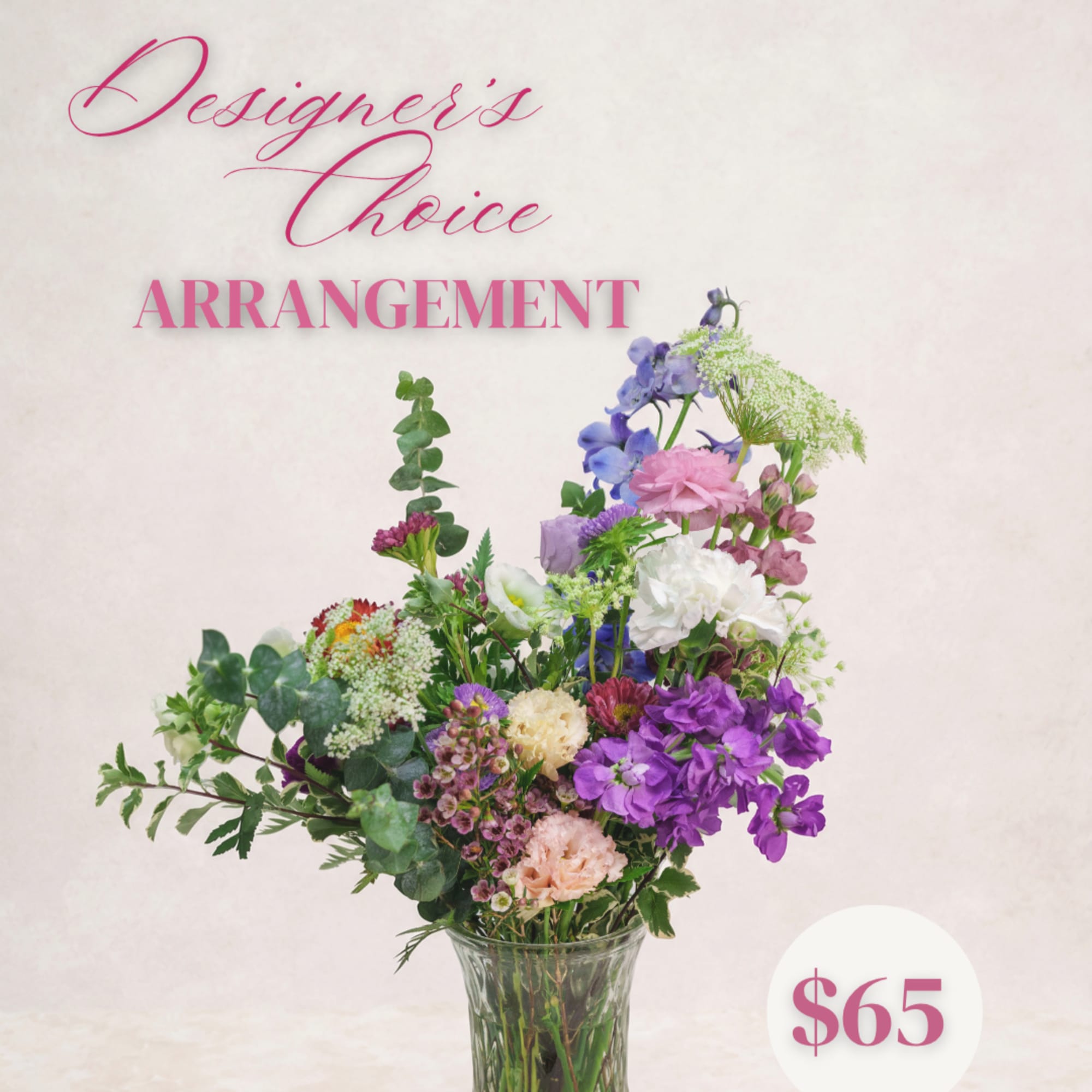 Mixed bouquet of purple, pink, and white flowers in a clear glass vase