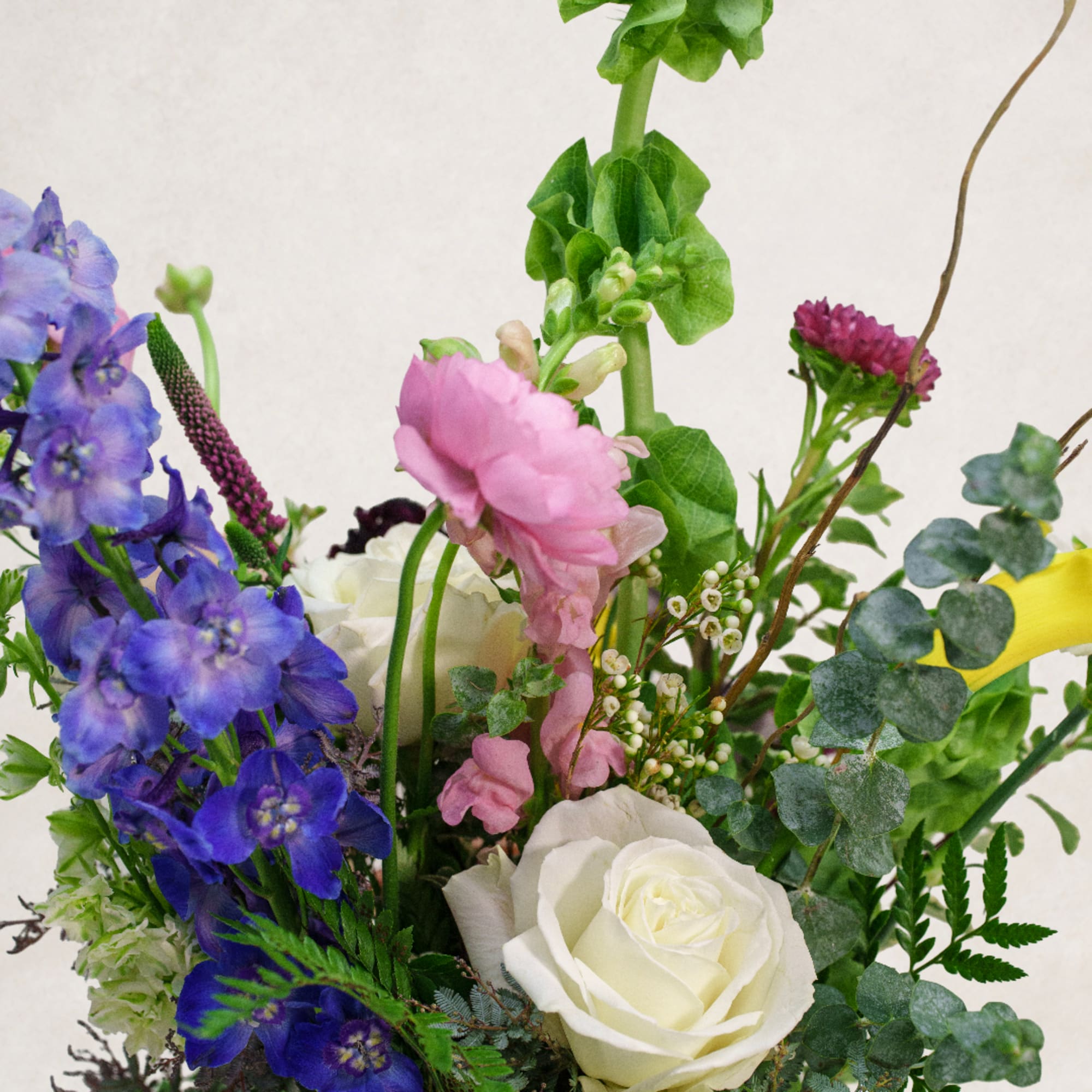Bouquet with blue delphinium, pink blooms, and white roses