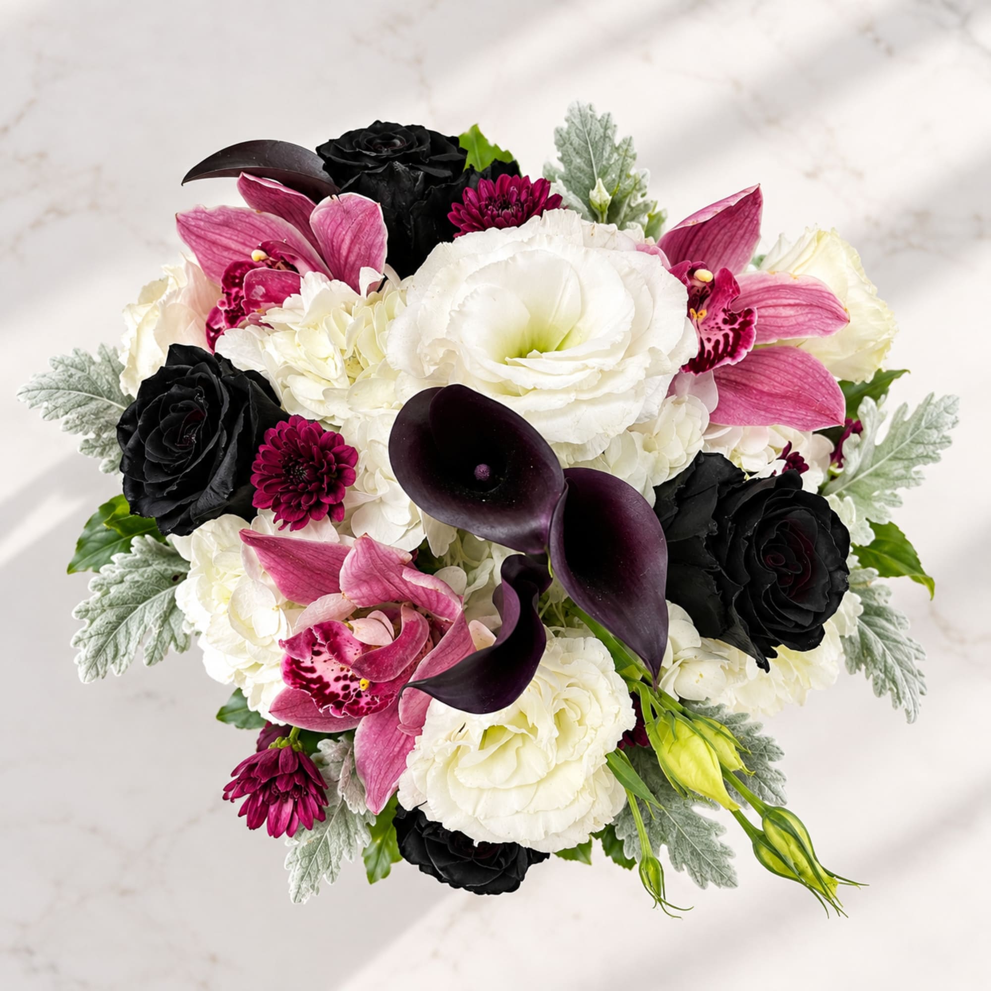Bouquet of white, pink, and black flowers with dark calla lilies