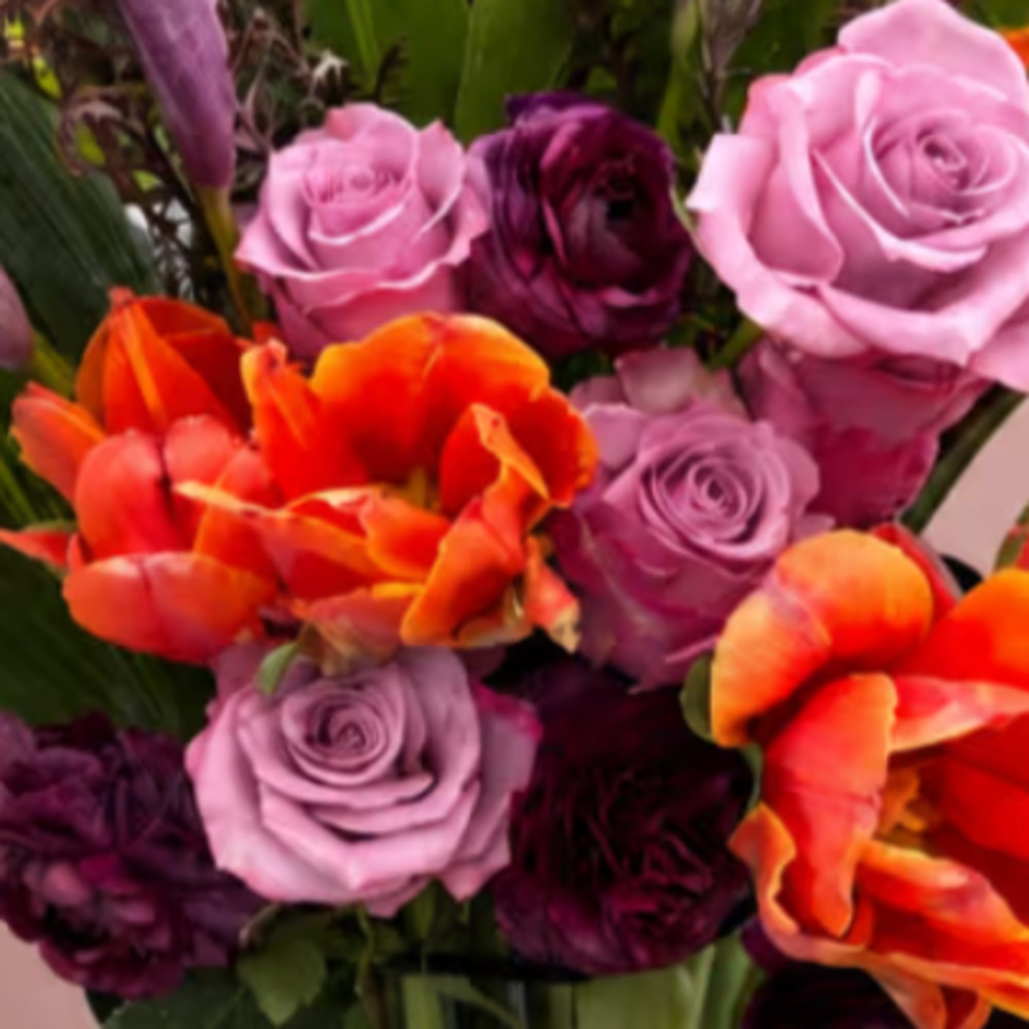 Bouquet of pink, purple, and orange roses with tulips