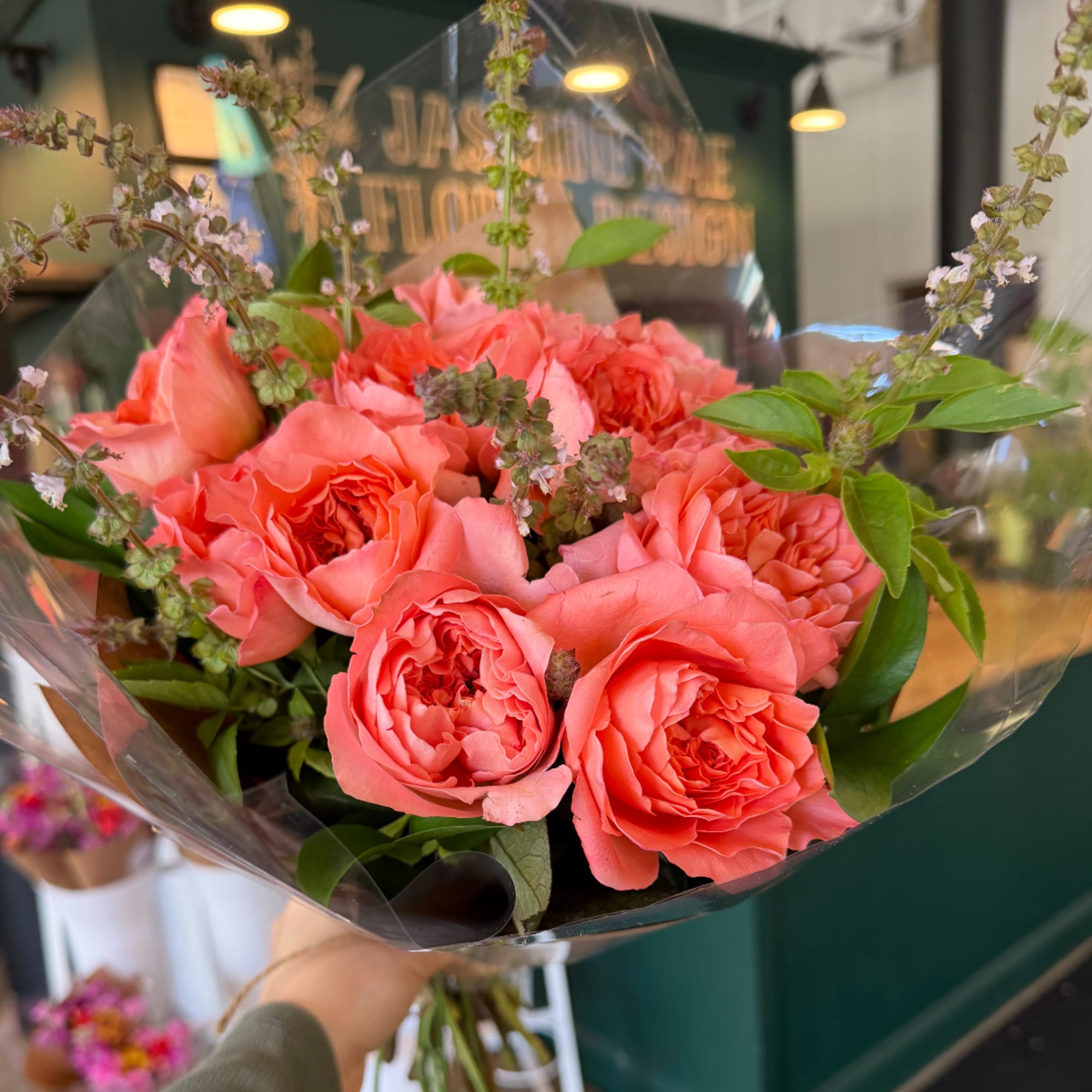 Coral-pink rose bouquet wrapped in clear plastic