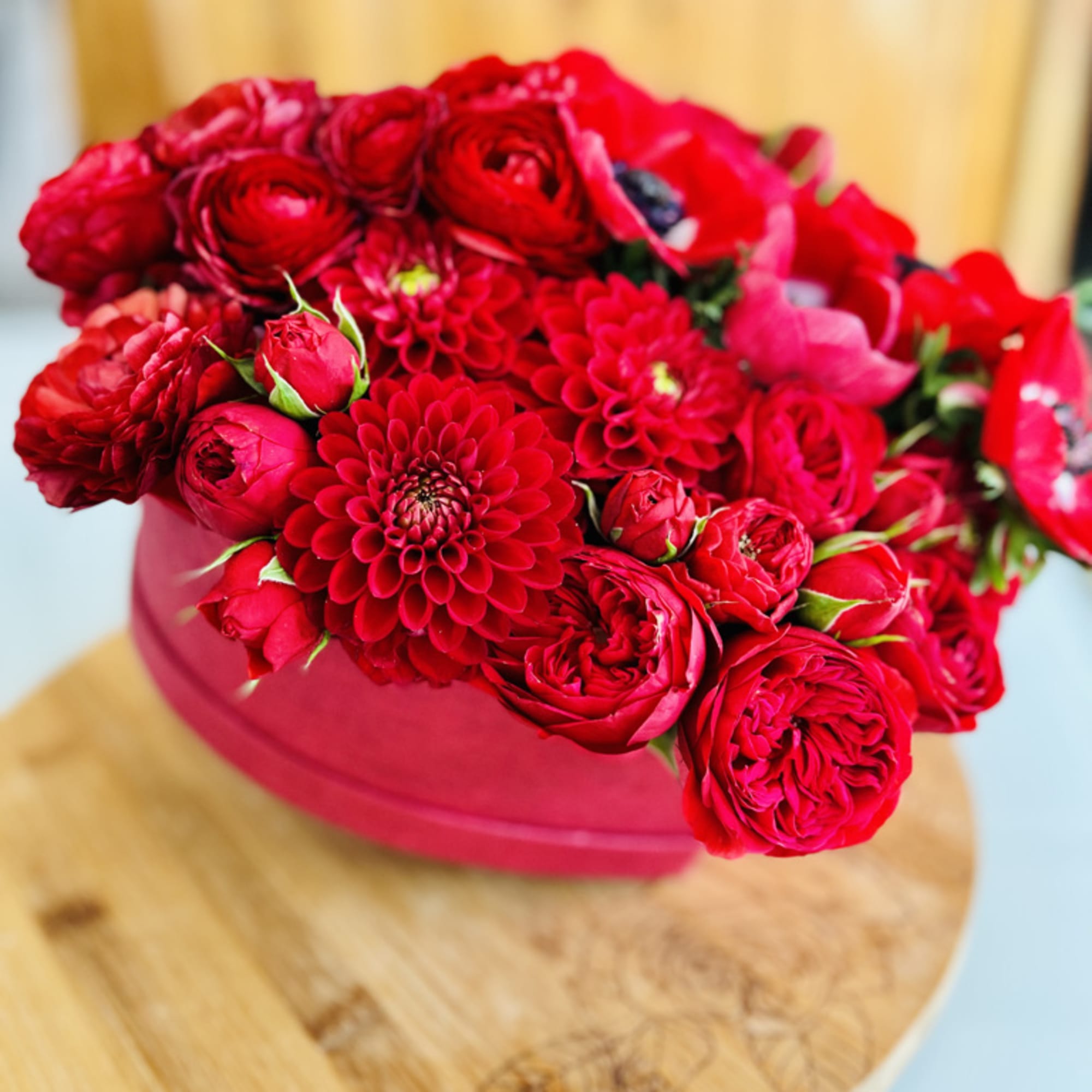 Red flower bouquet in a pink hat box