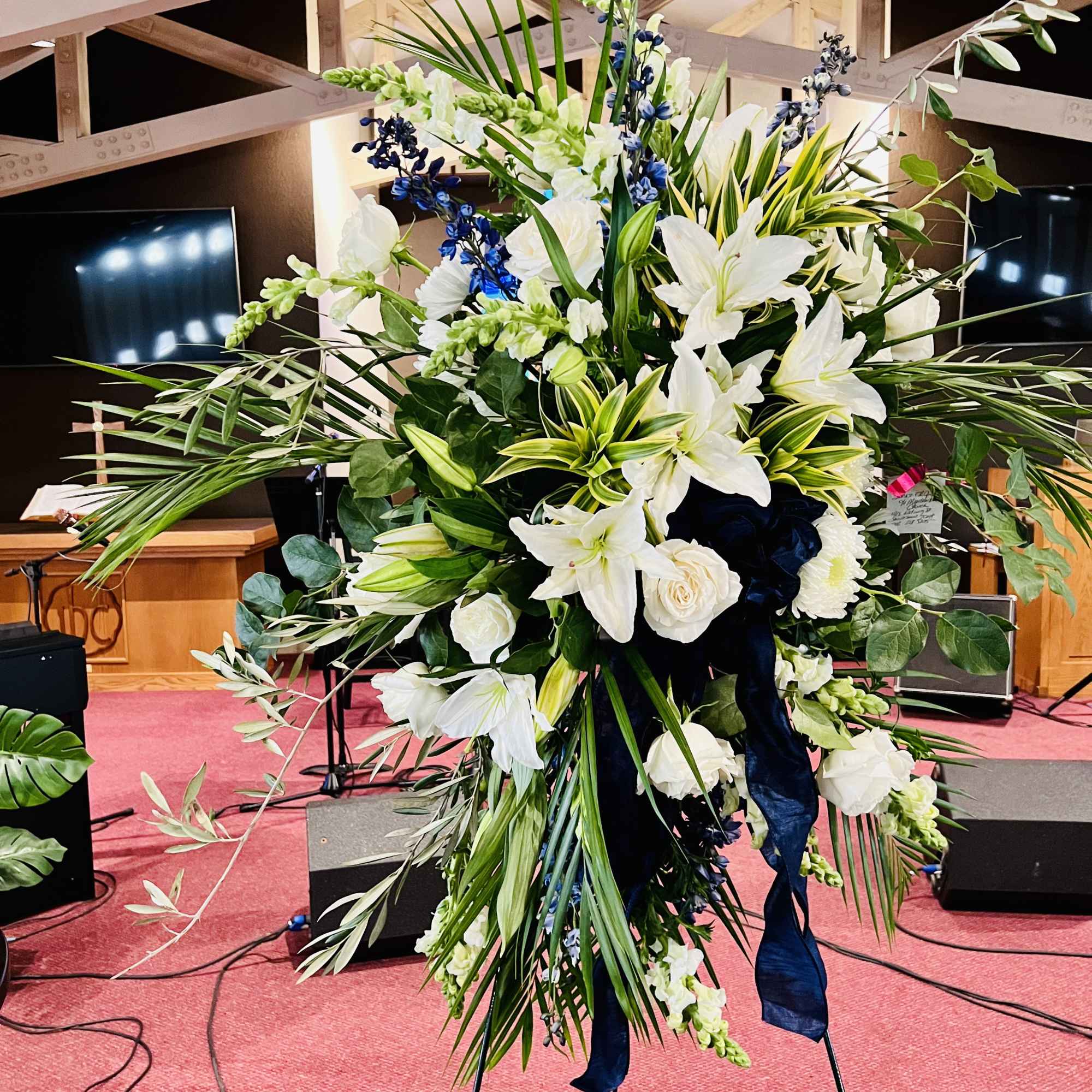 Large white and blue floral standing arrangement on an easel