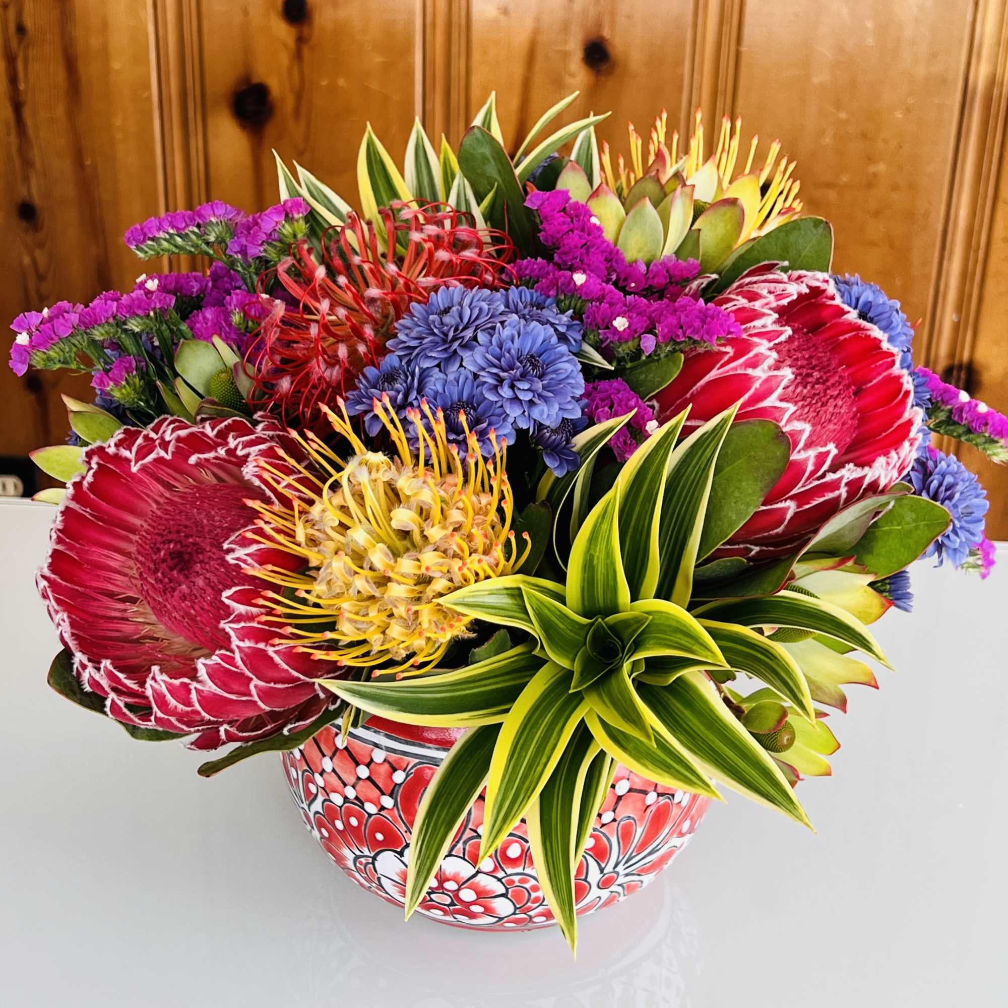 Colorful tropical bouquet in a patterned ceramic bowl