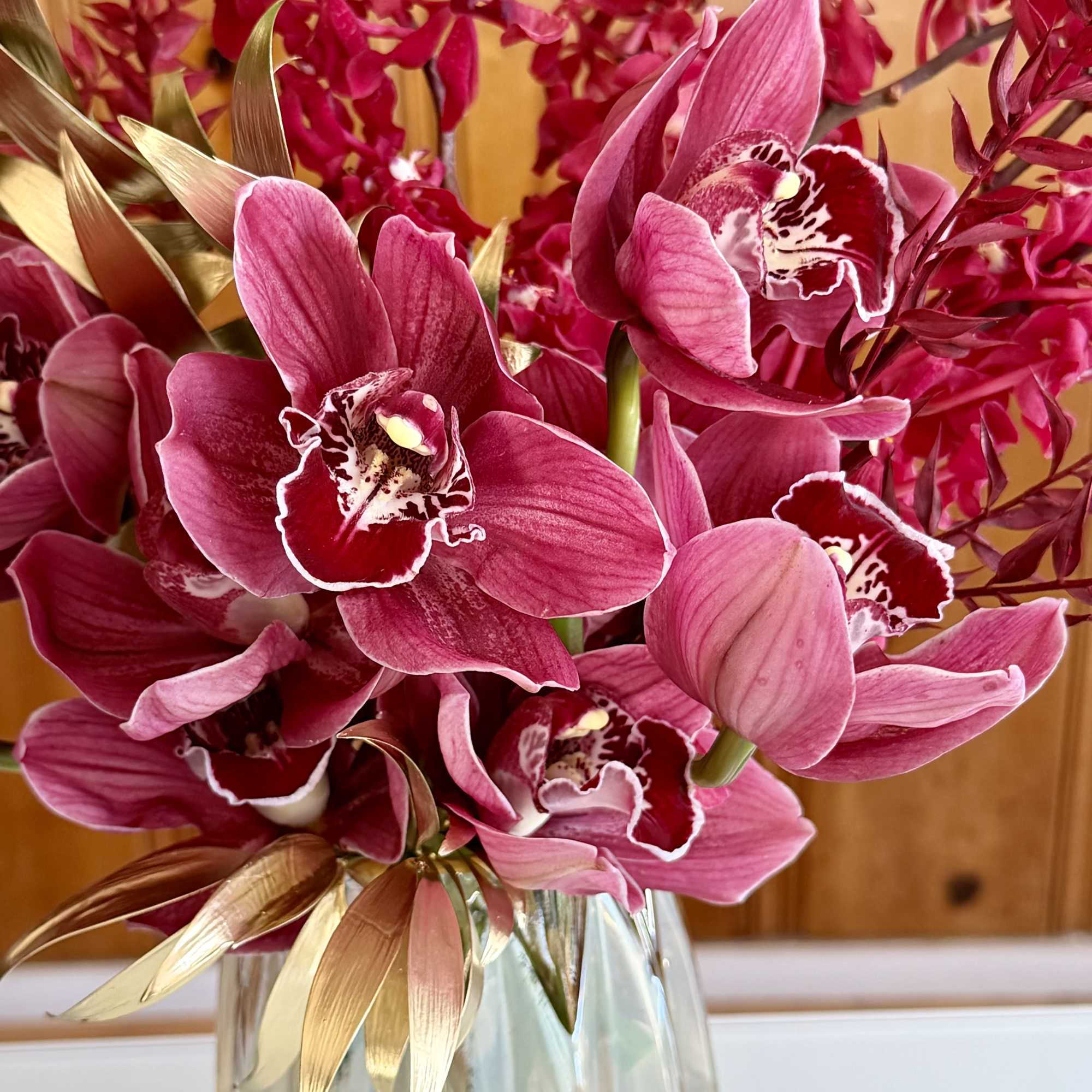 Pink orchids arranged in a clear glass vase