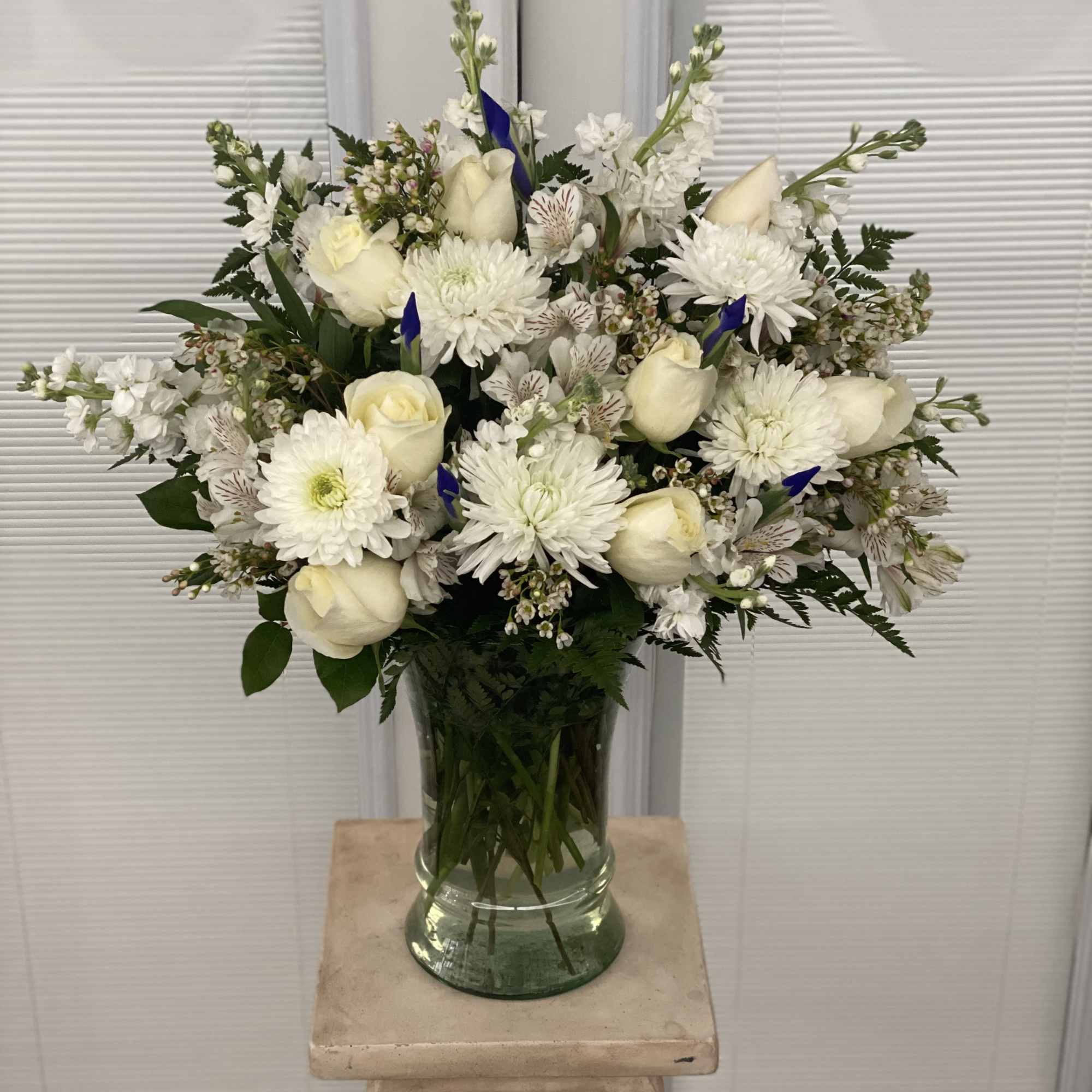 Beautiful in blue and white, our abundant sympathy arrangement makes a fitting